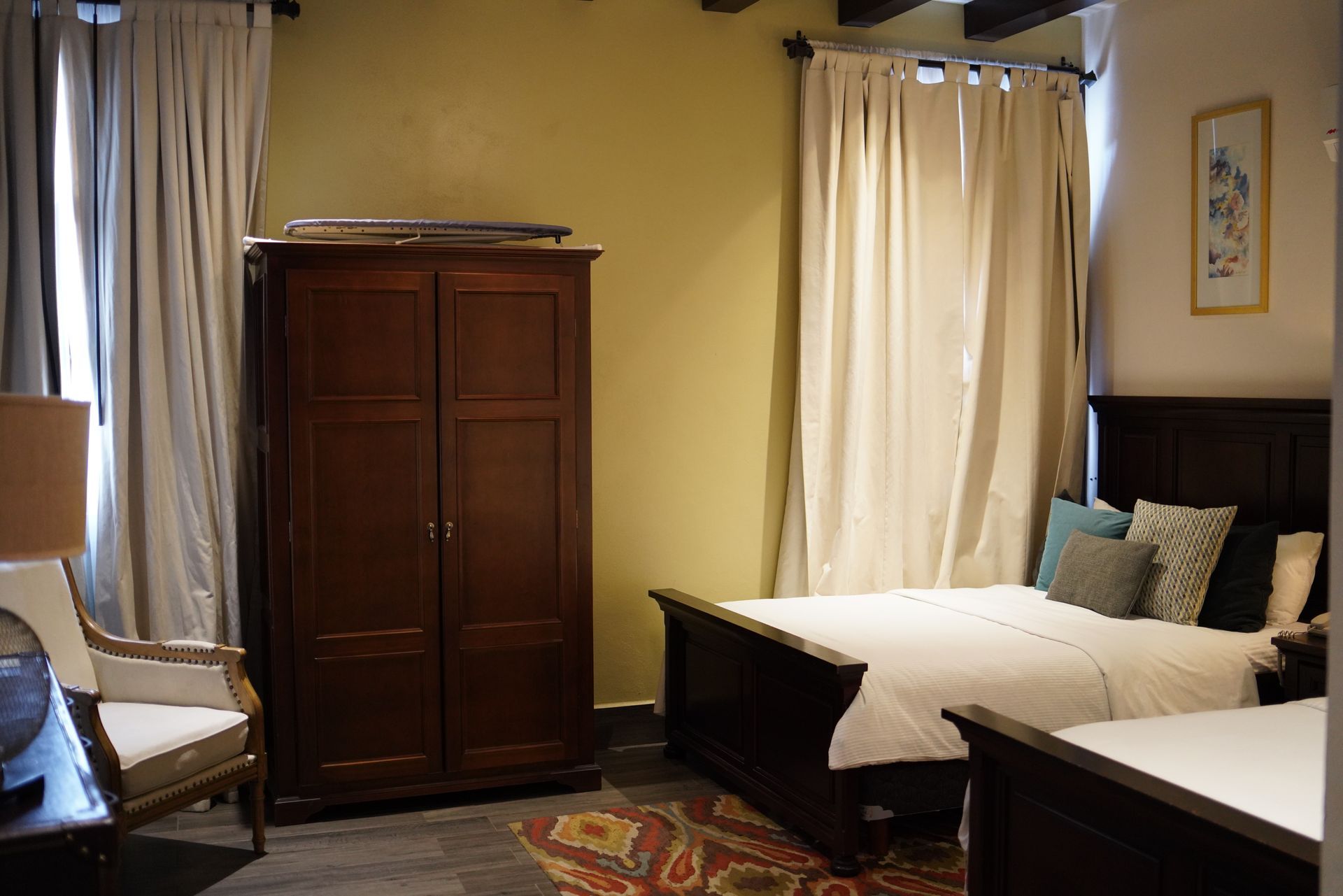 A bedroom with two beds , a chair and a wardrobe.
