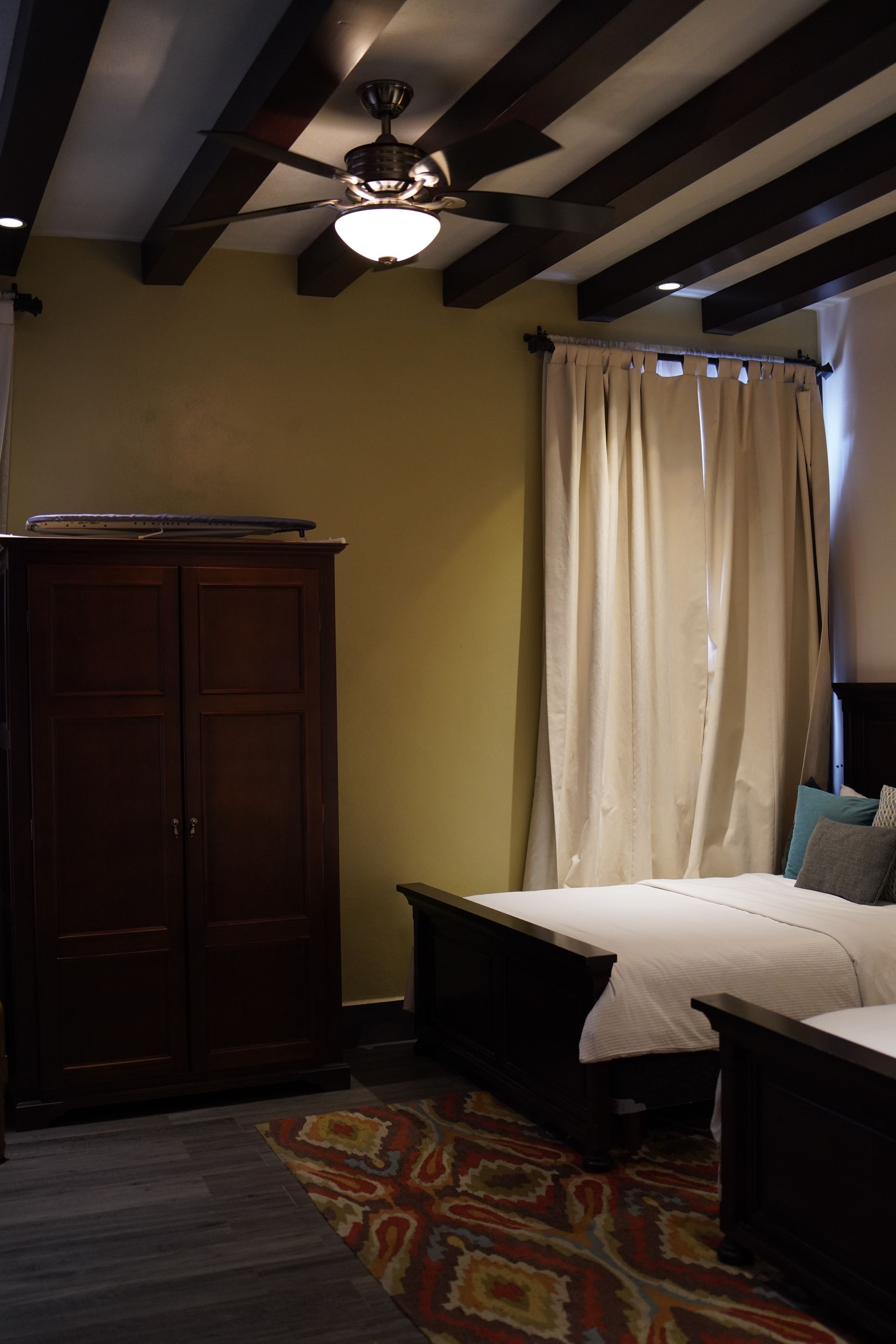 A bedroom with a bed and a ceiling fan