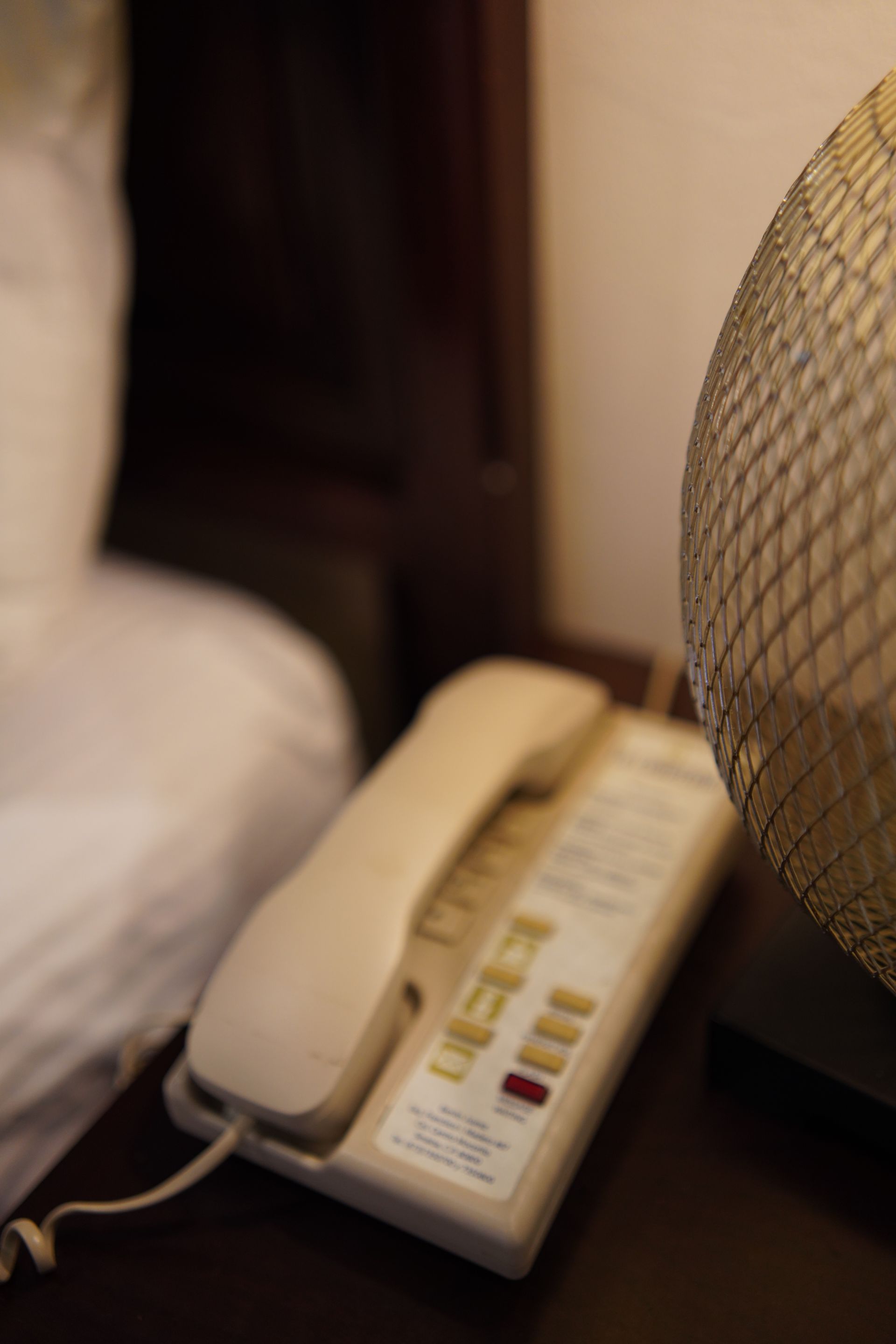 A telephone is sitting on a table next to a lamp