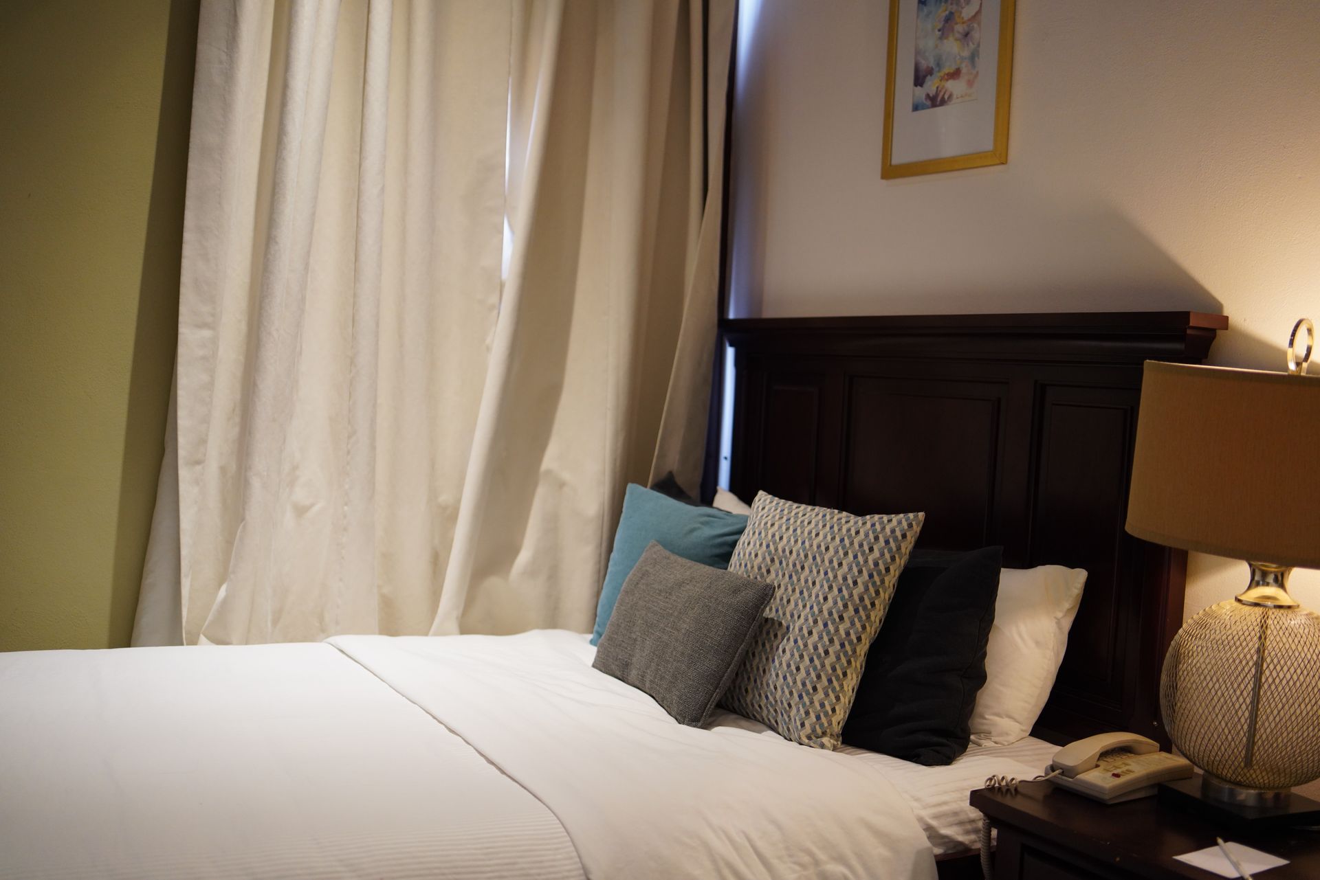 A hotel room with a bed and a lamp