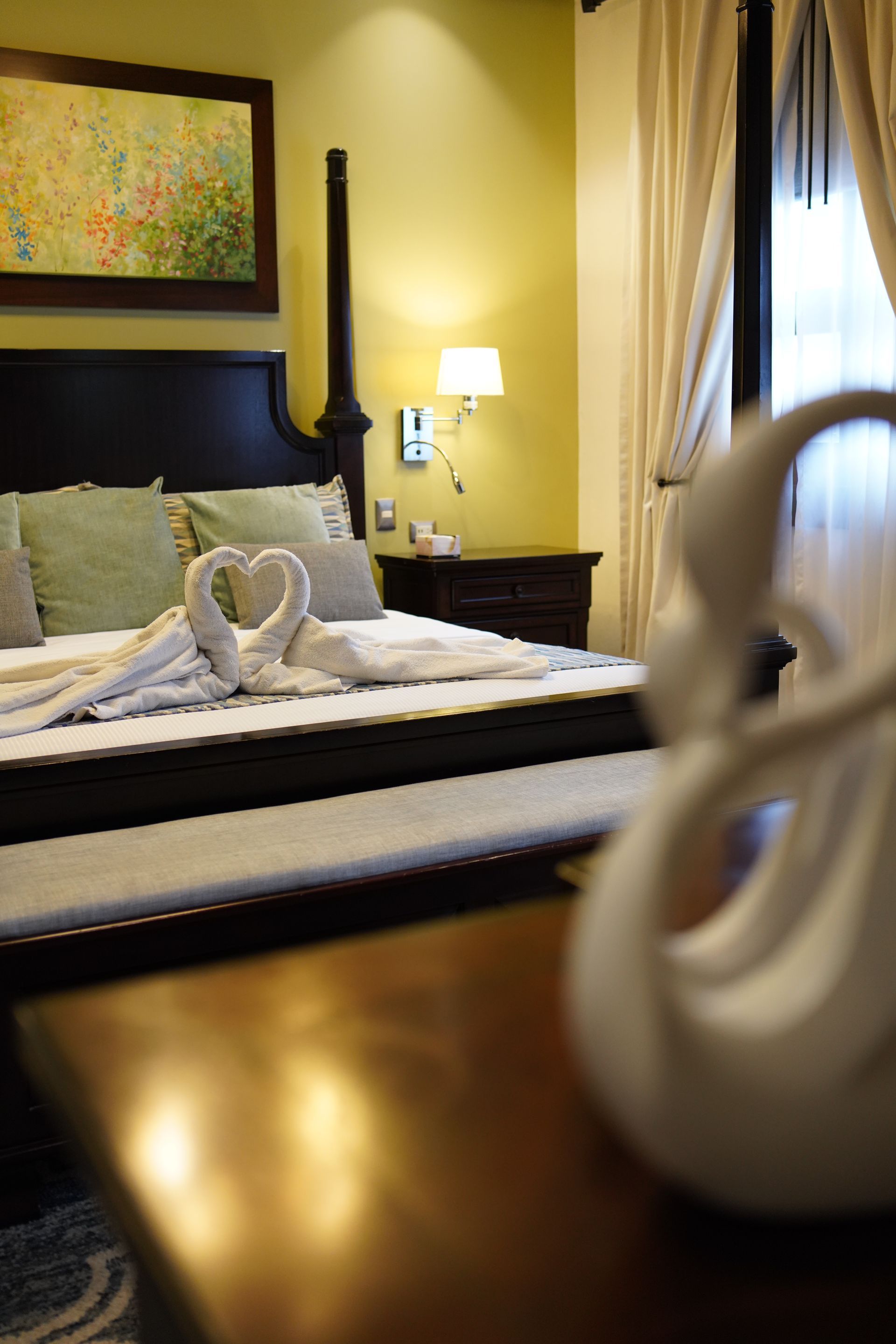 A bedroom with a bed and a table with a swan on it