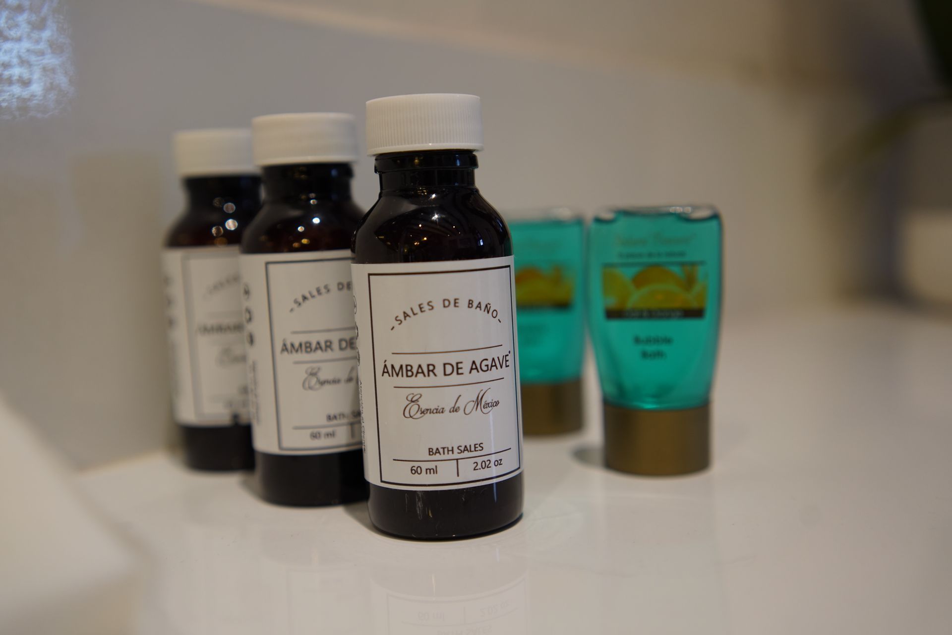 A bottle of amber oil is sitting on a table next to other bottles.