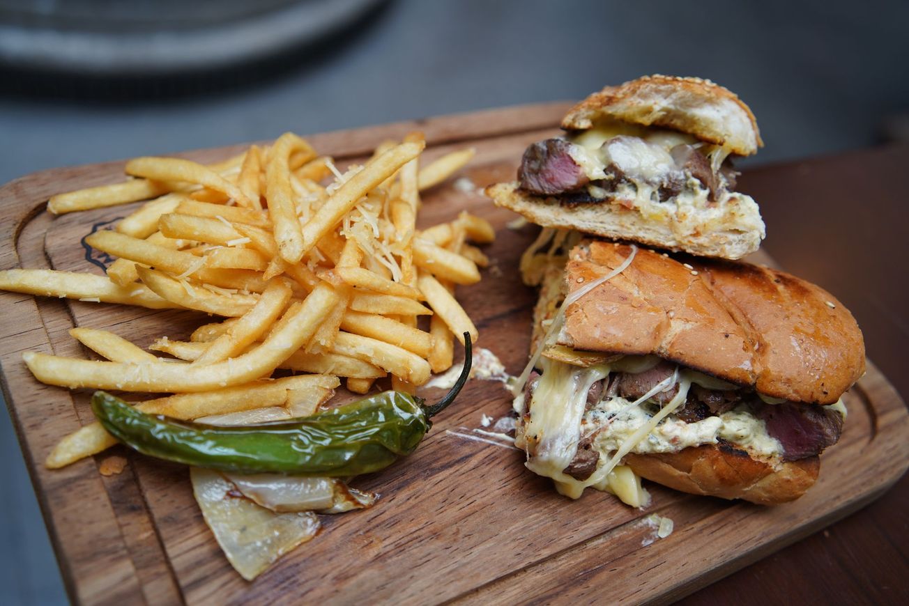 Un sándwich y papas fritas en una tabla de cortar de madera.
