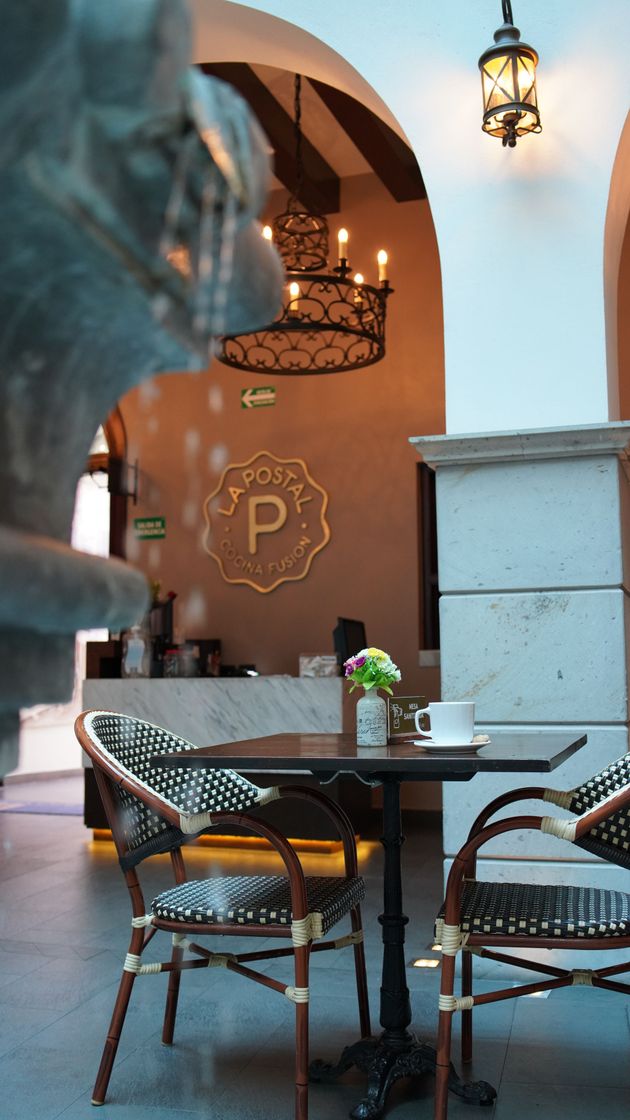 Una mesa y sillas en un restaurante con la letra p en la pared.