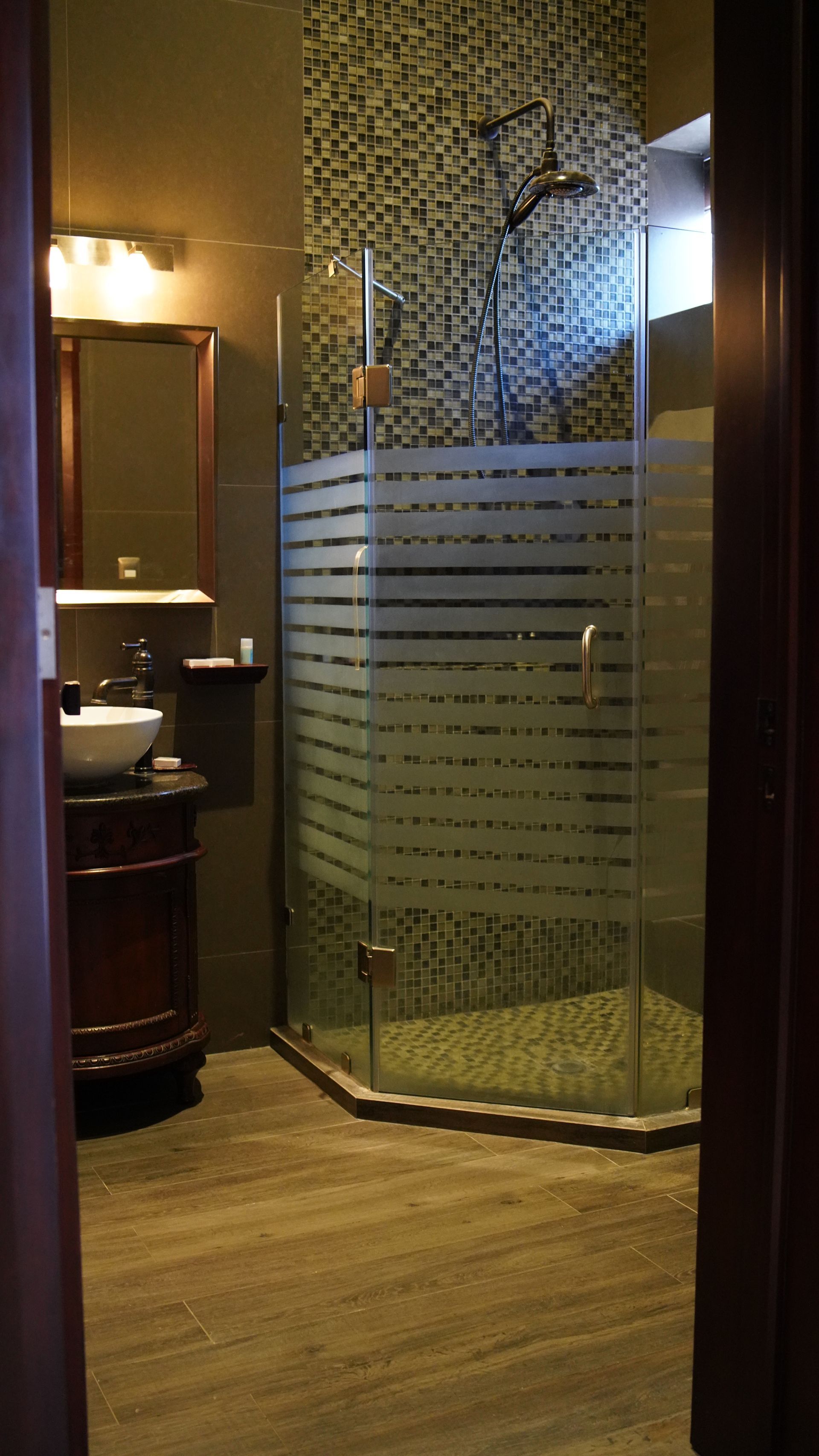 A bathroom with a walk in shower and a sink.