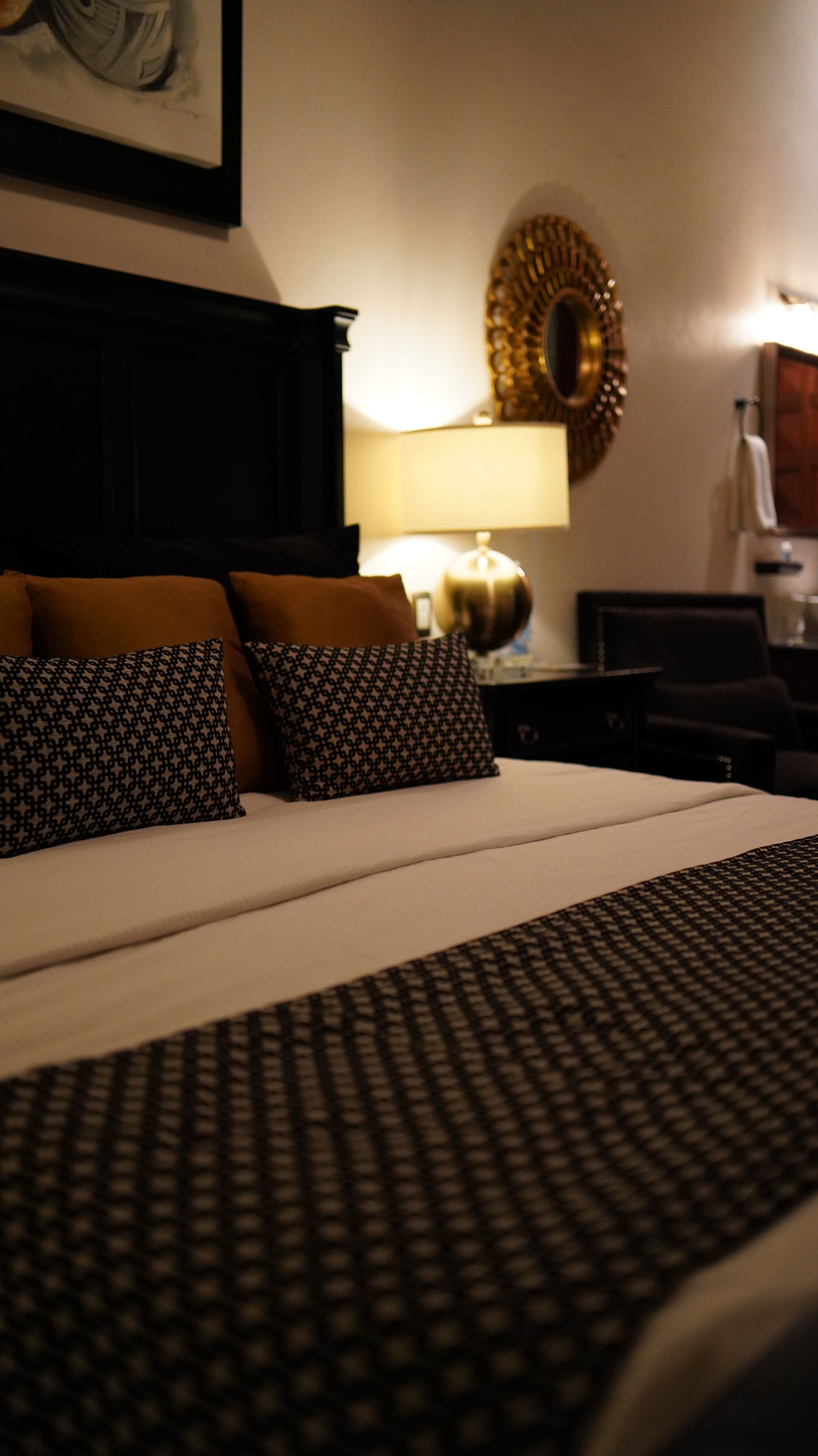 A hotel room with a bed and two lamps