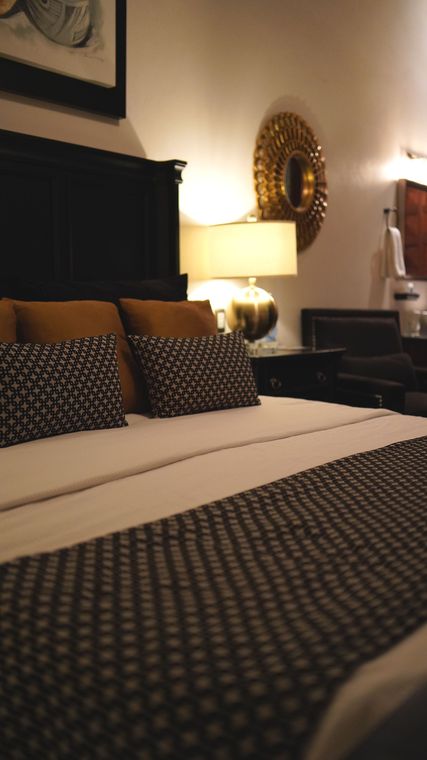 Una habitación de hotel con una cama grande y lámparas.