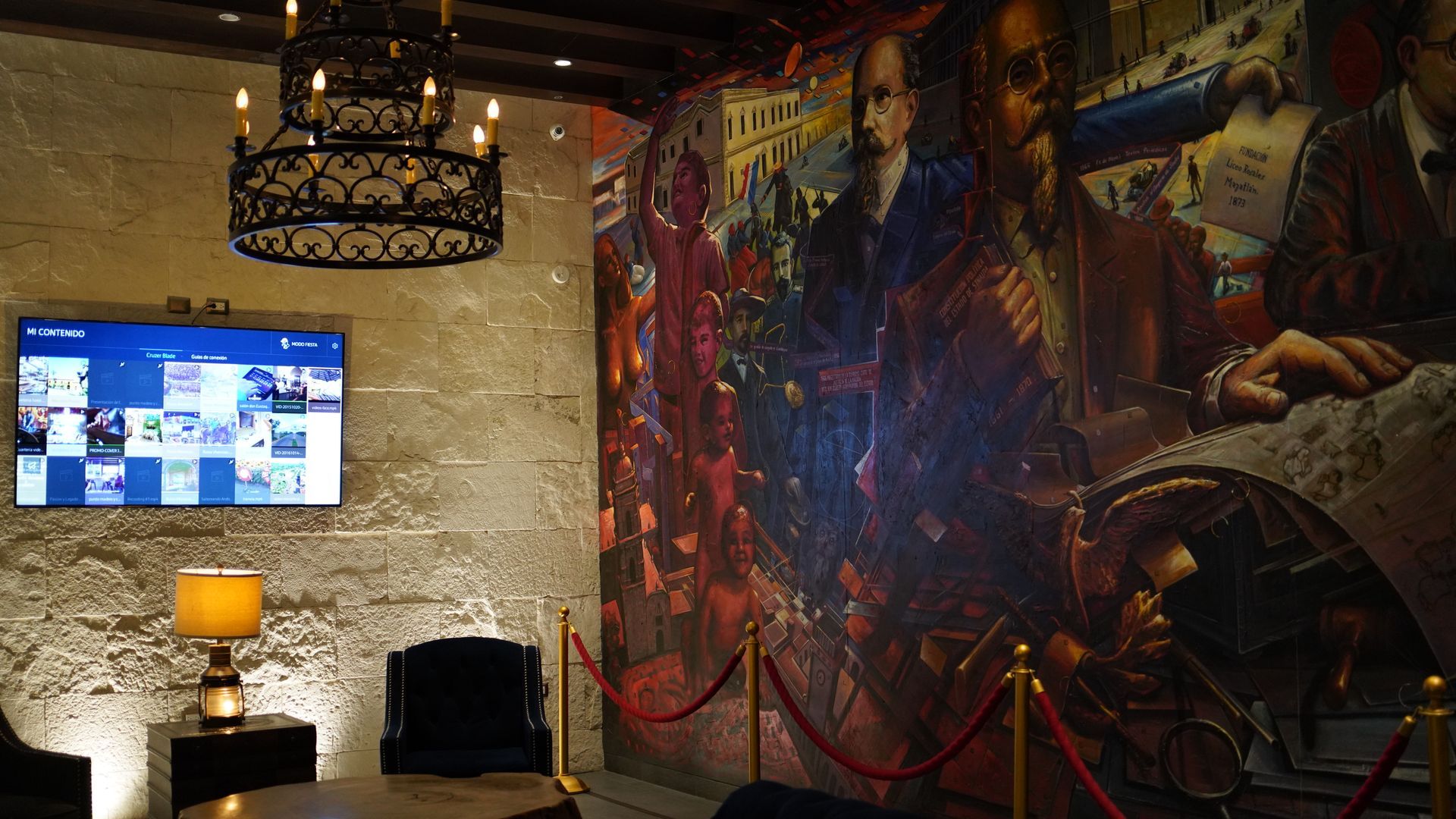 A room with a painting on the wall and a television on the wall.