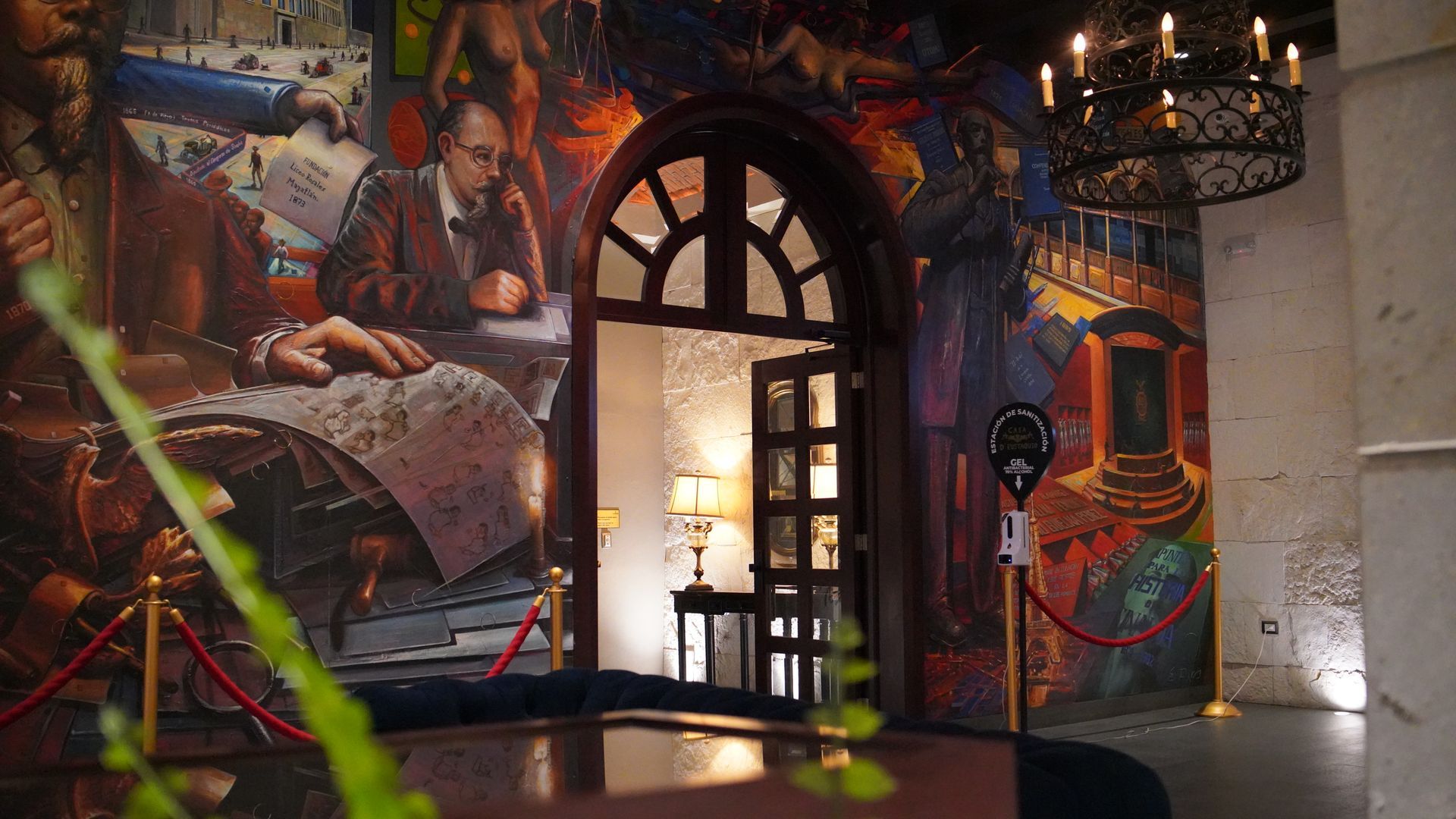 A room with a painting on the wall and a table in front of it.