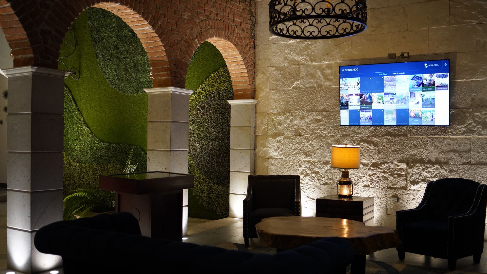 A living room with a table and chairs and a flat screen tv on the wall.