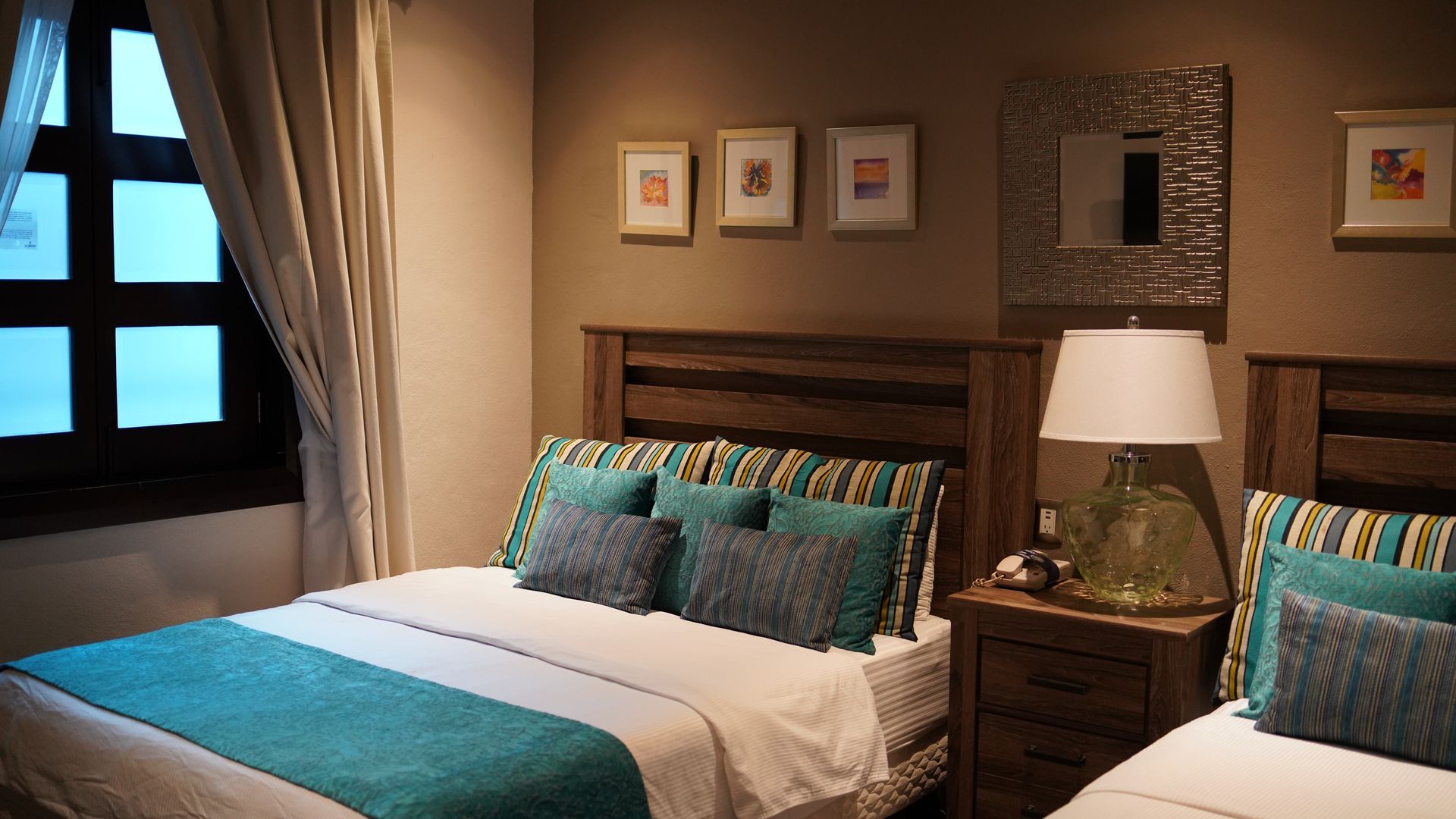 A hotel room with two beds and a lamp