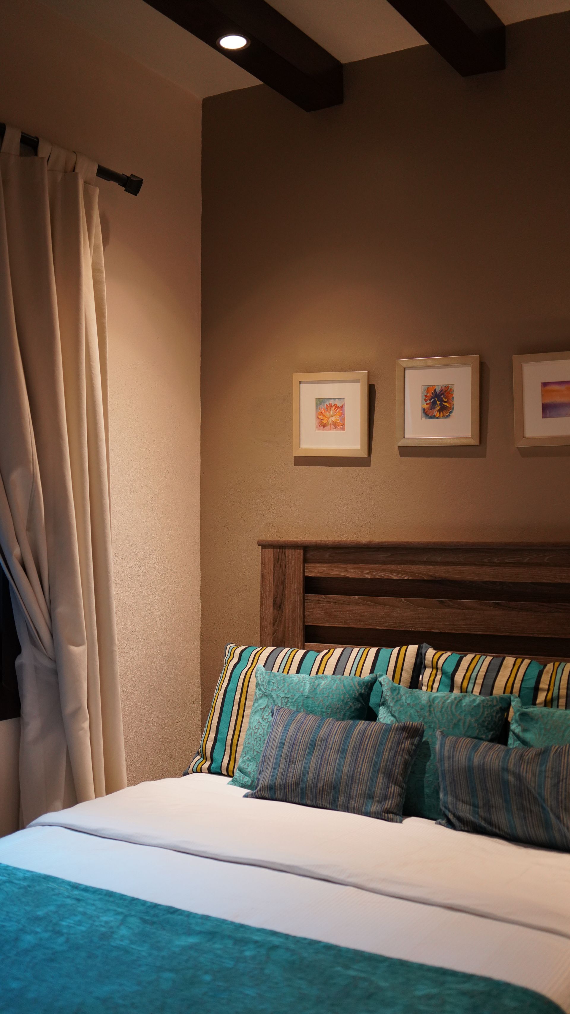 A bedroom with a bed , pillows , and a window.
