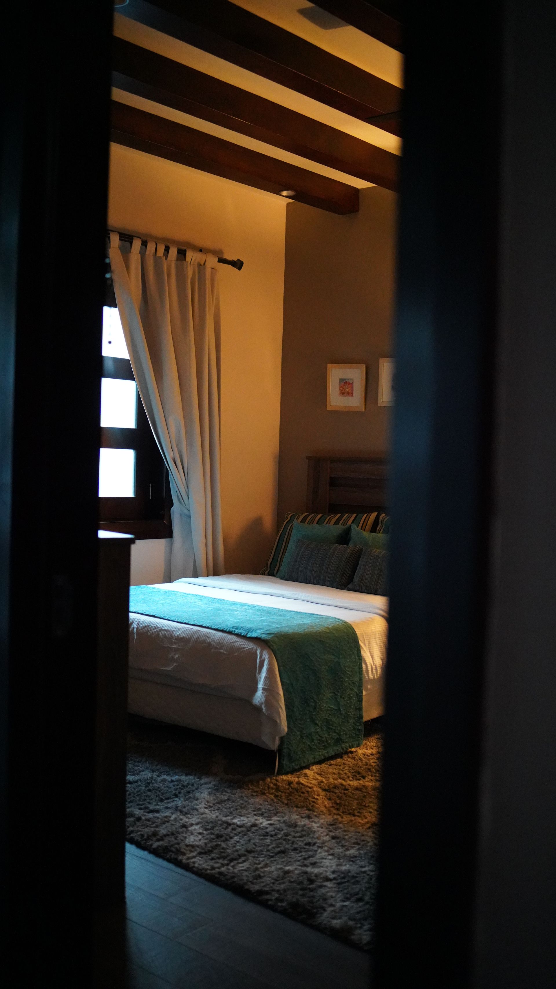 A bedroom with a bed and a window.