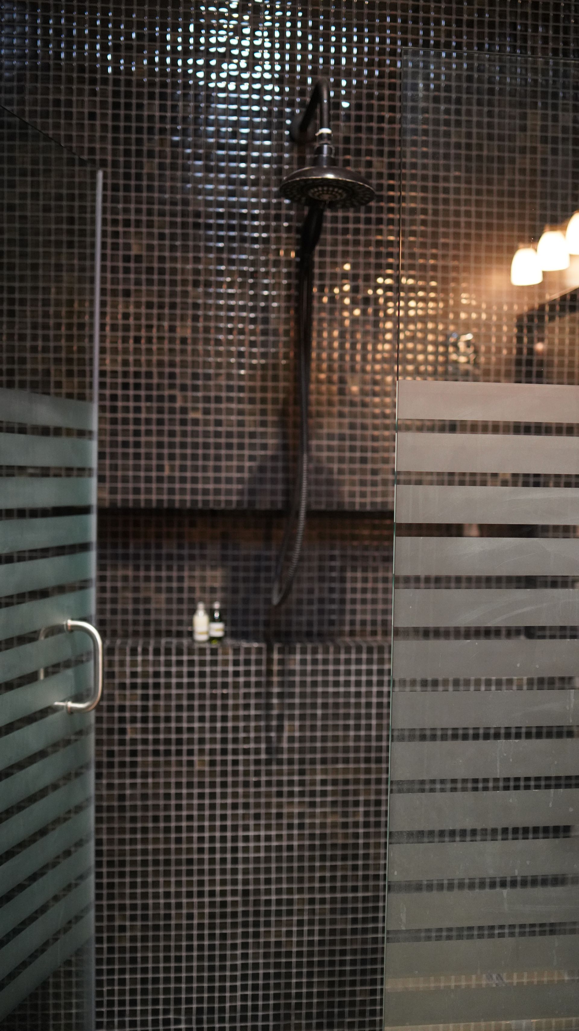 A shower stall with a glass door and a shower head.