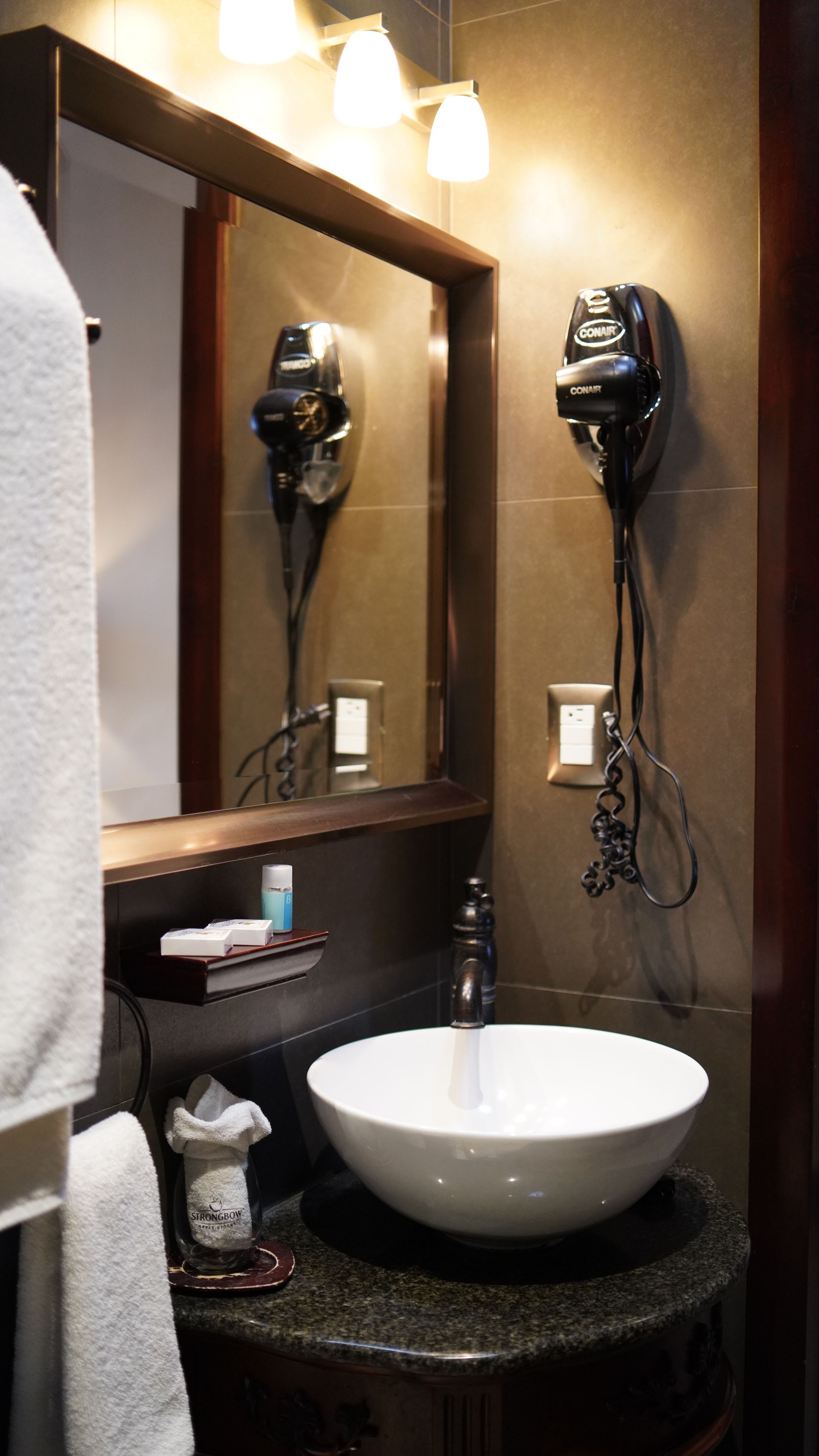 A bathroom with a sink , mirror and hair dryer