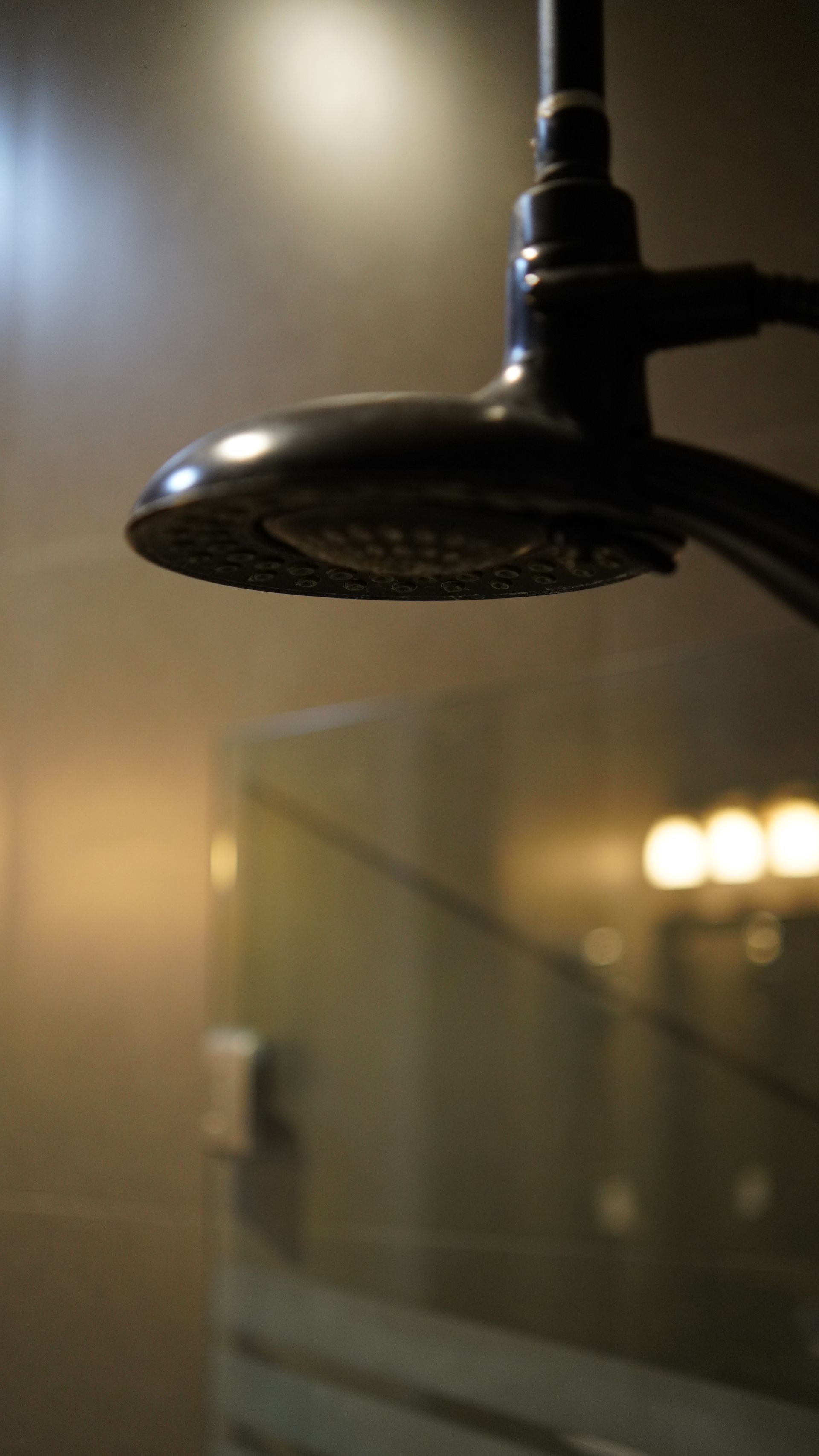 A close up of a shower head in a bathroom.