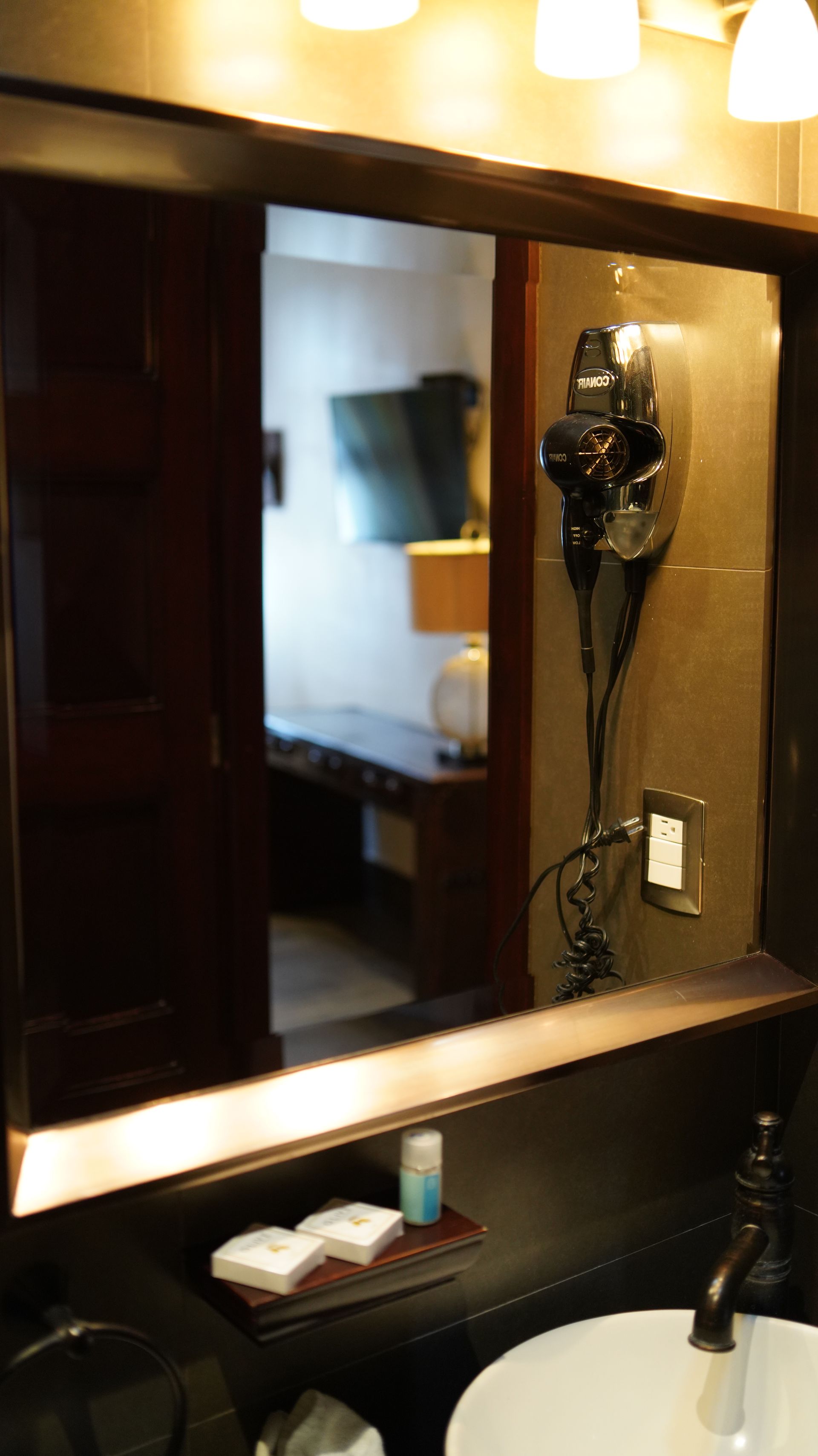 A bathroom with a sink a mirror and a hair dryer