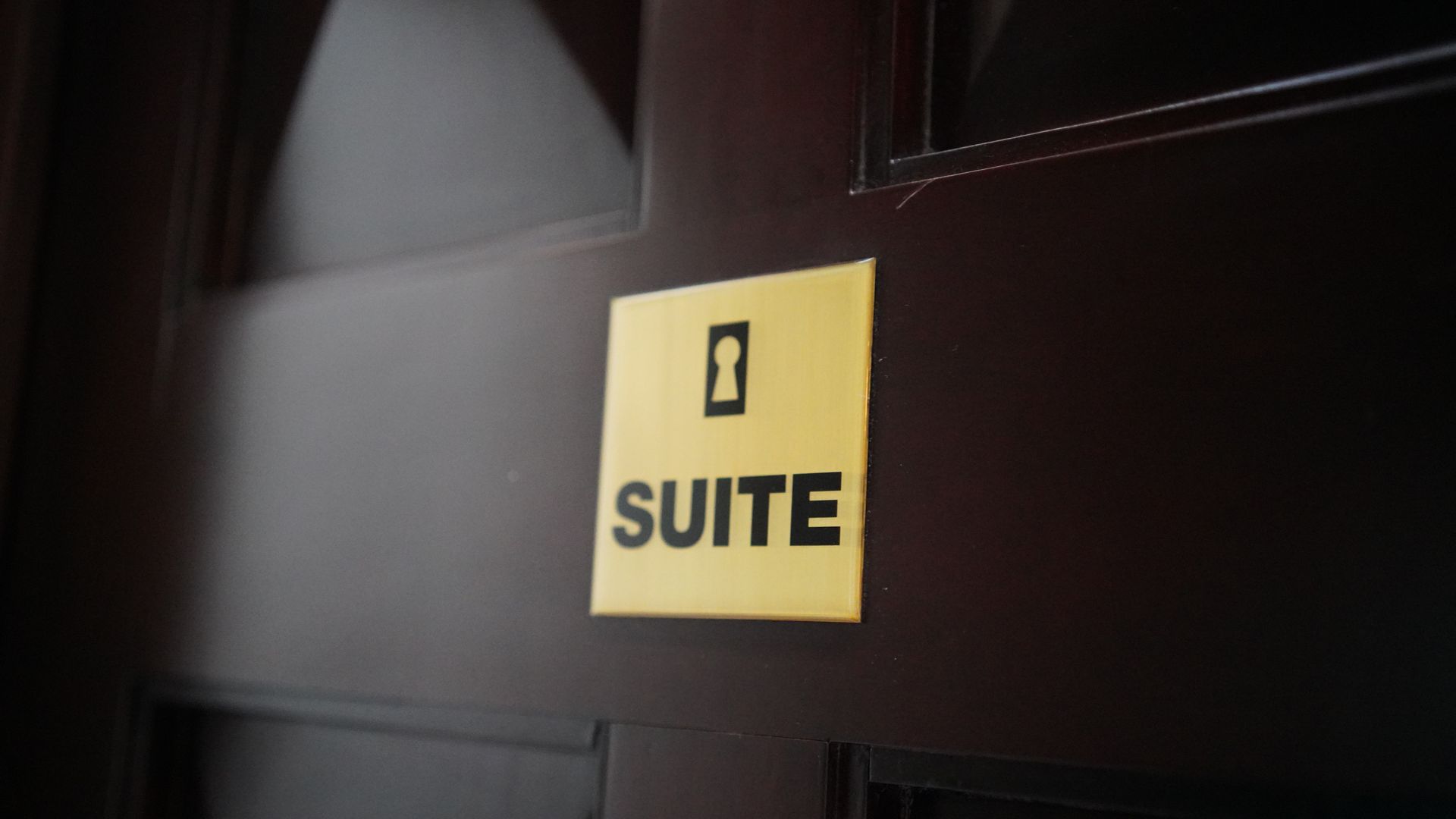 A sign on a door that says suite on it