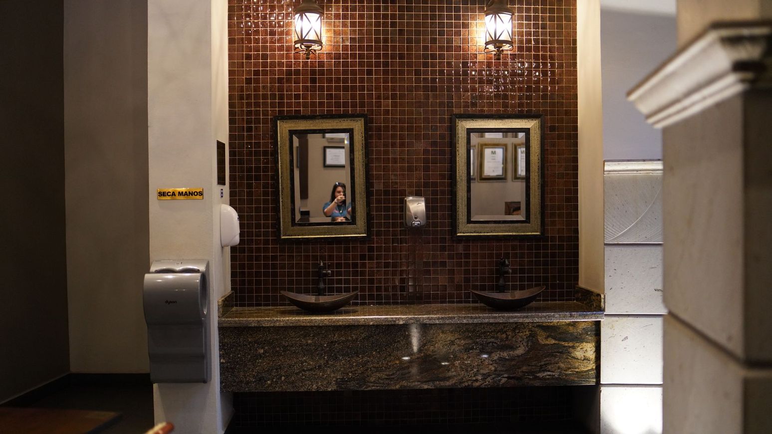 Un baño con dos lavabos y dos espejos en la pared.
