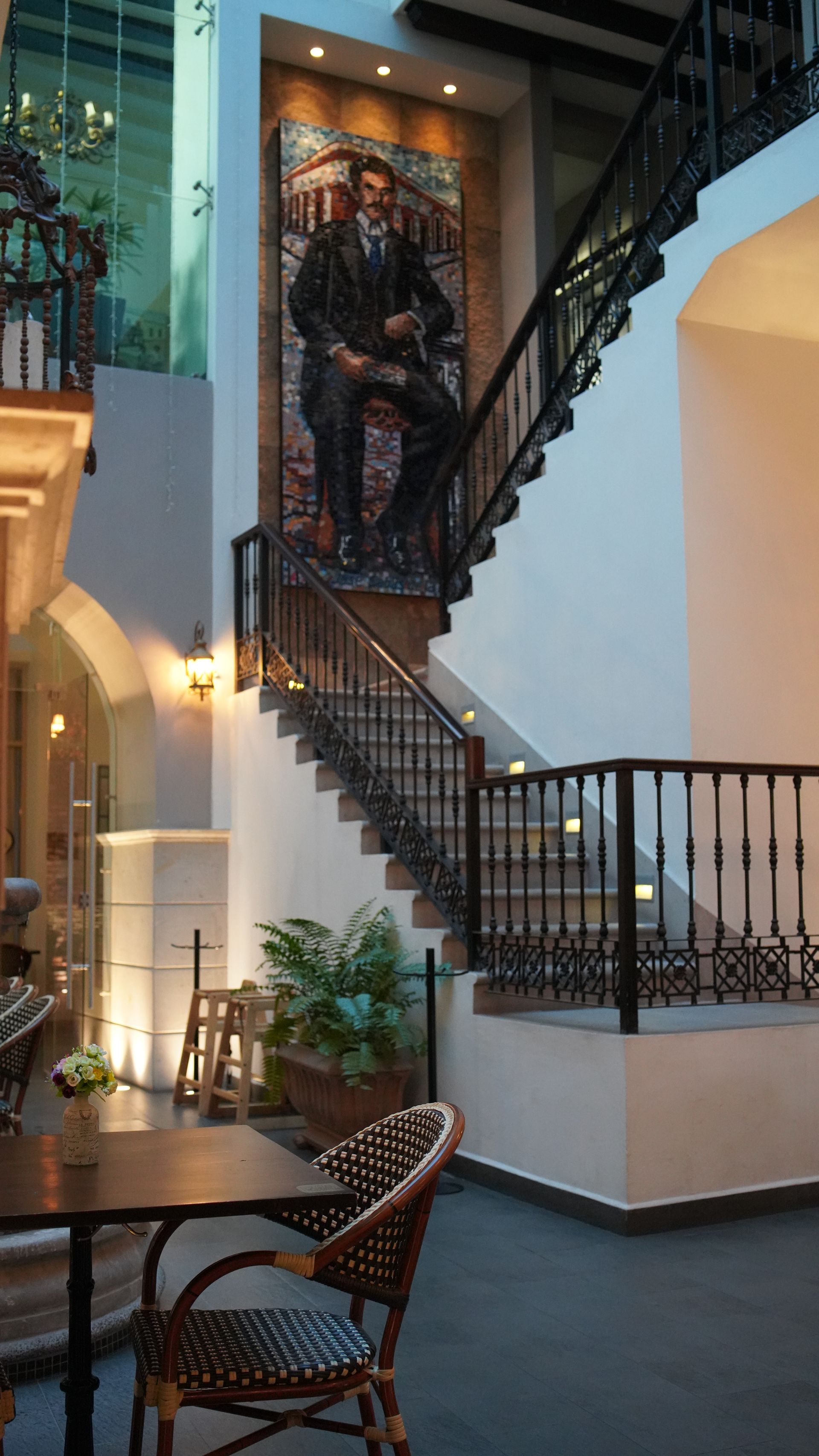 A staircase with a painting of a man sitting on it