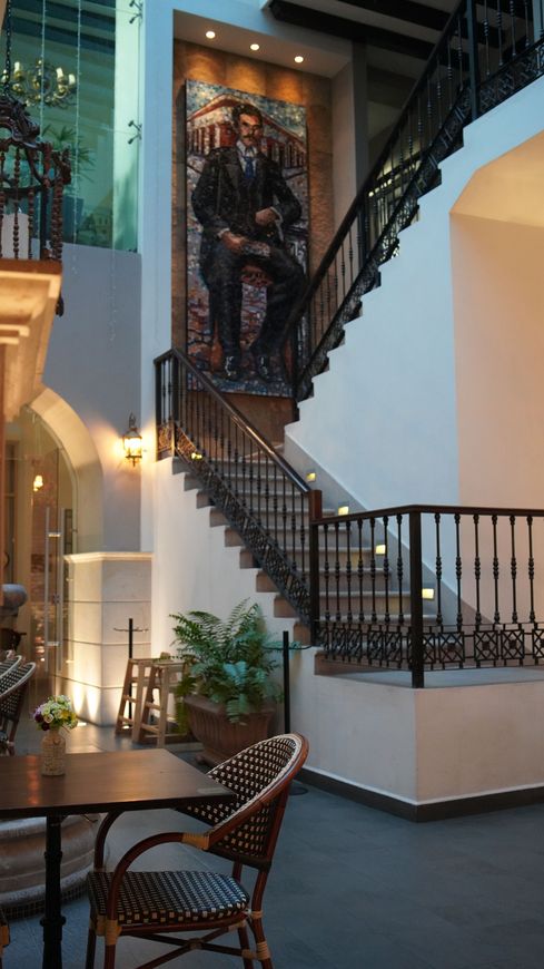 Una escalera con una pintura de un hombre sentado en ella.