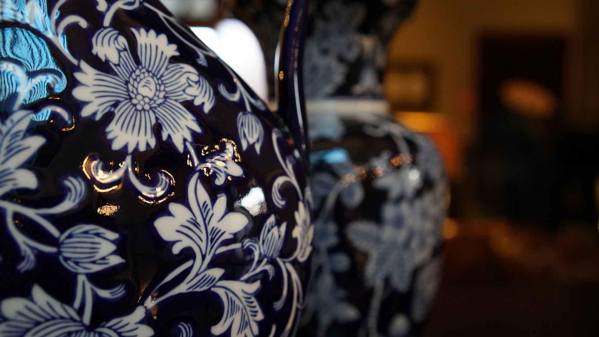 A close up of a blue and white vase with a floral pattern