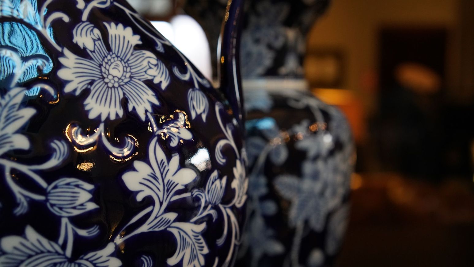 Un primer plano de un jarrón azul y blanco con un patrón floral.