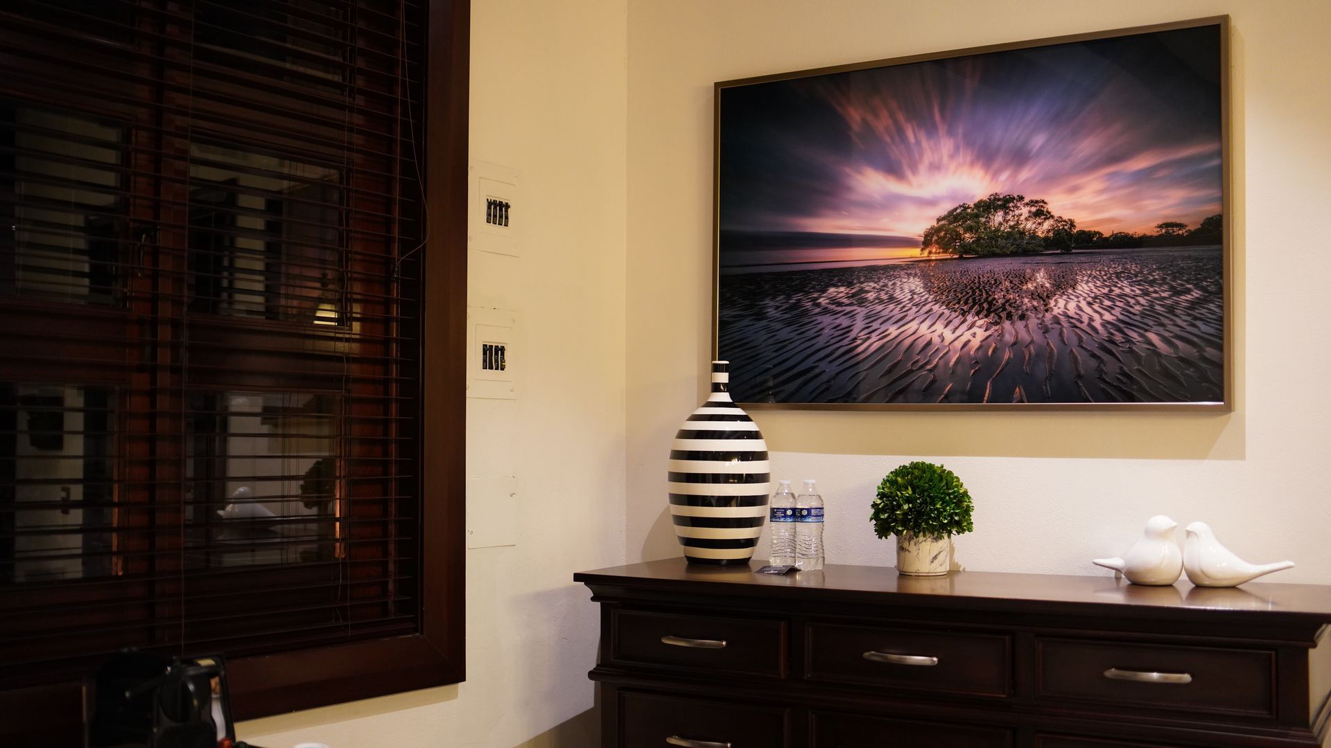 There is a picture on the wall above the dresser.