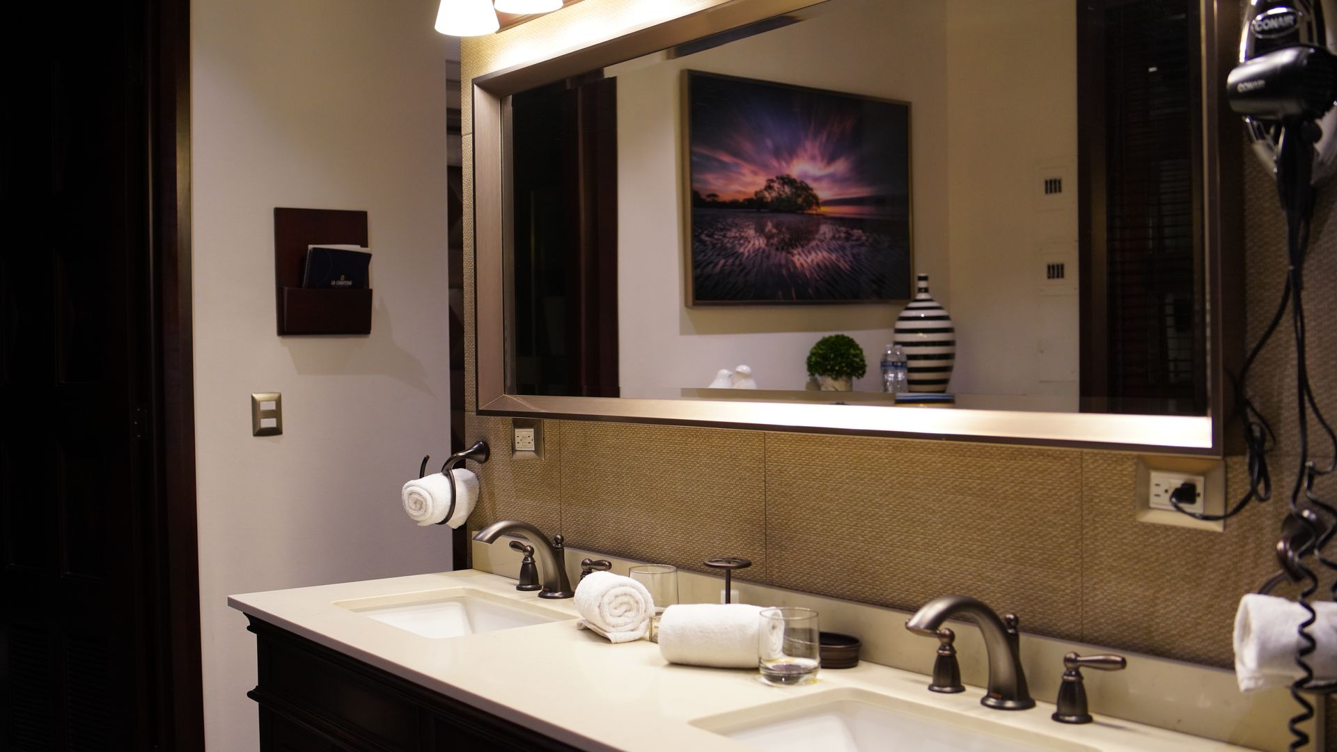 A bathroom with two sinks and a large mirror.
