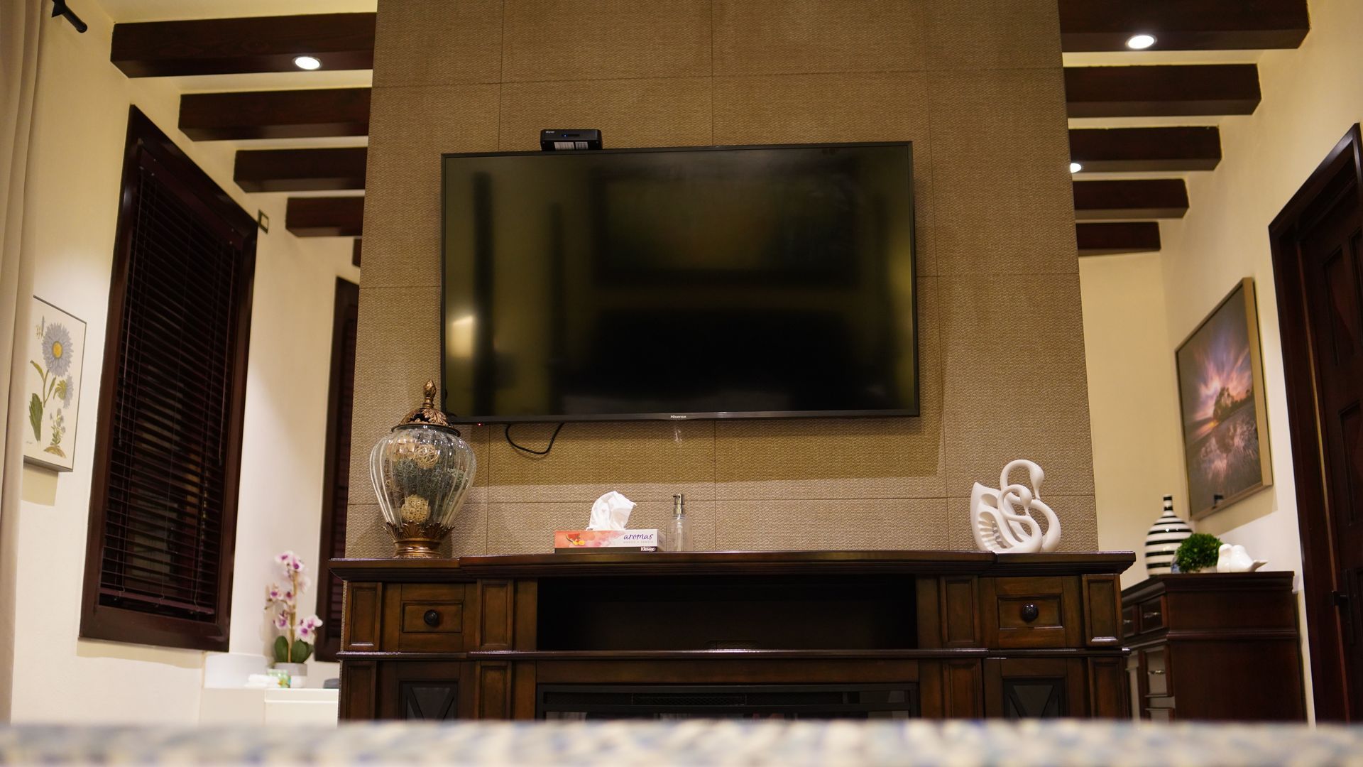 A living room with a fireplace and a flat screen tv on the wall.