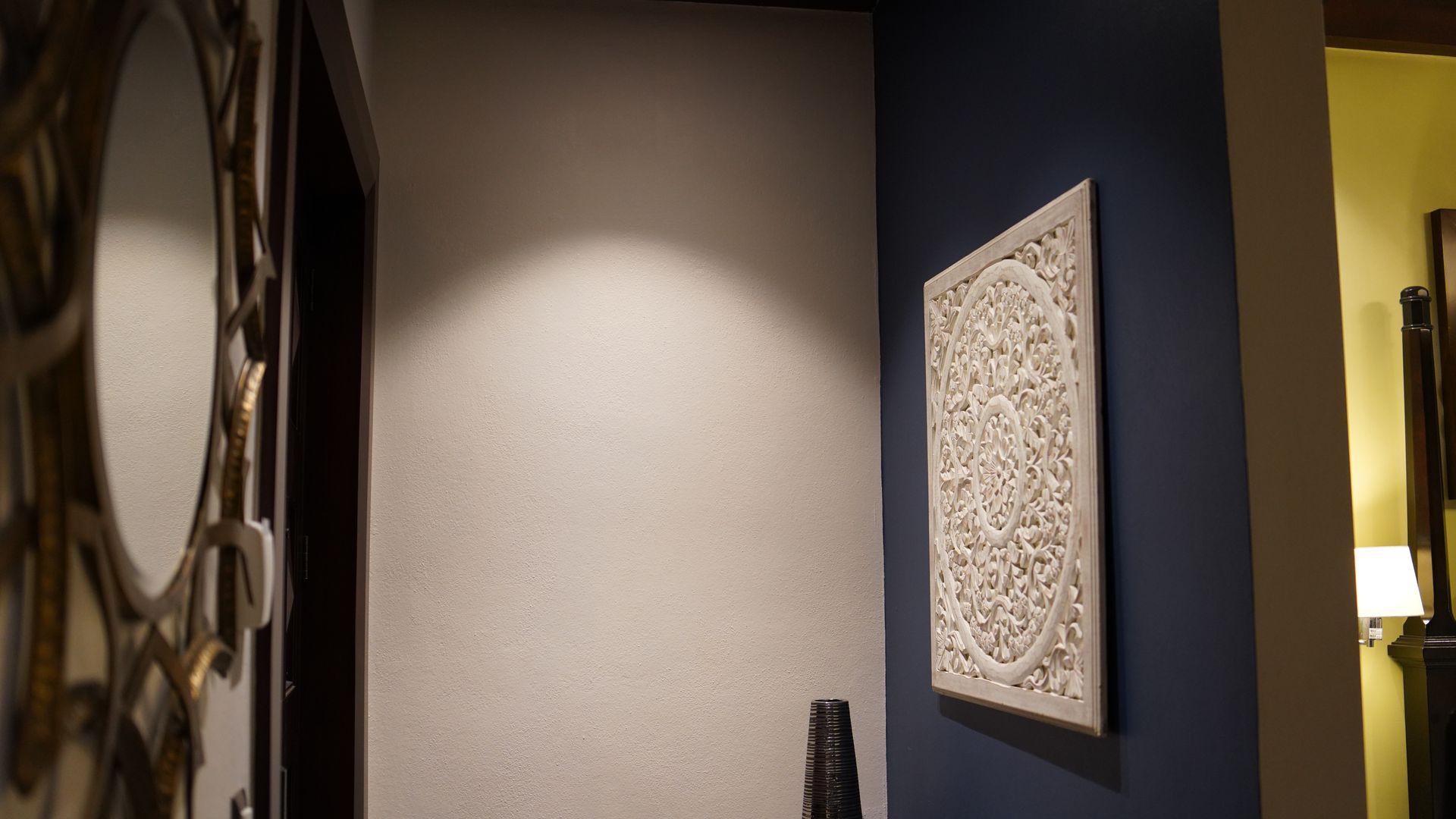 A hallway with a mirror and a picture on the wall