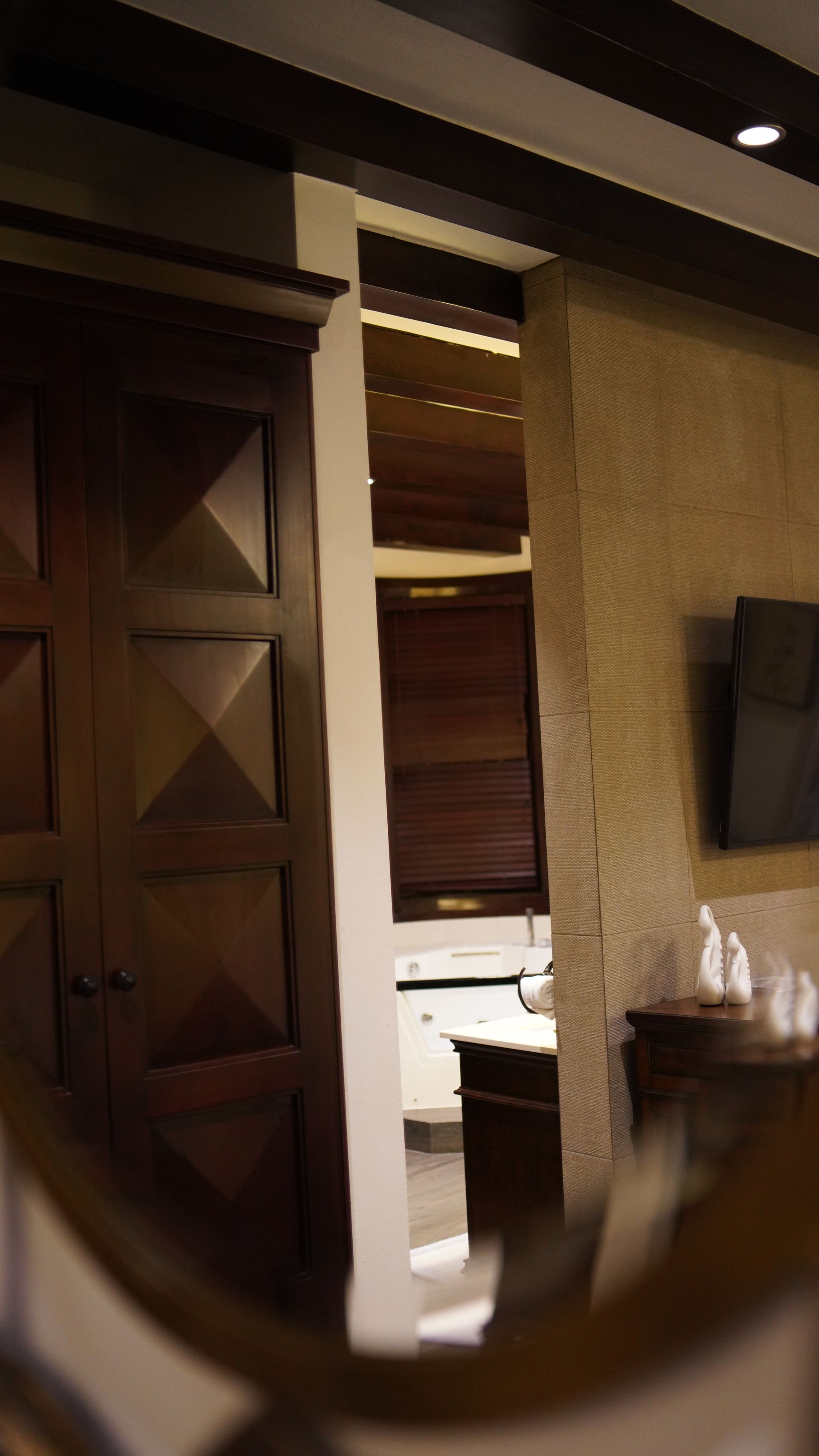 A room with a wooden door and a television on the wall