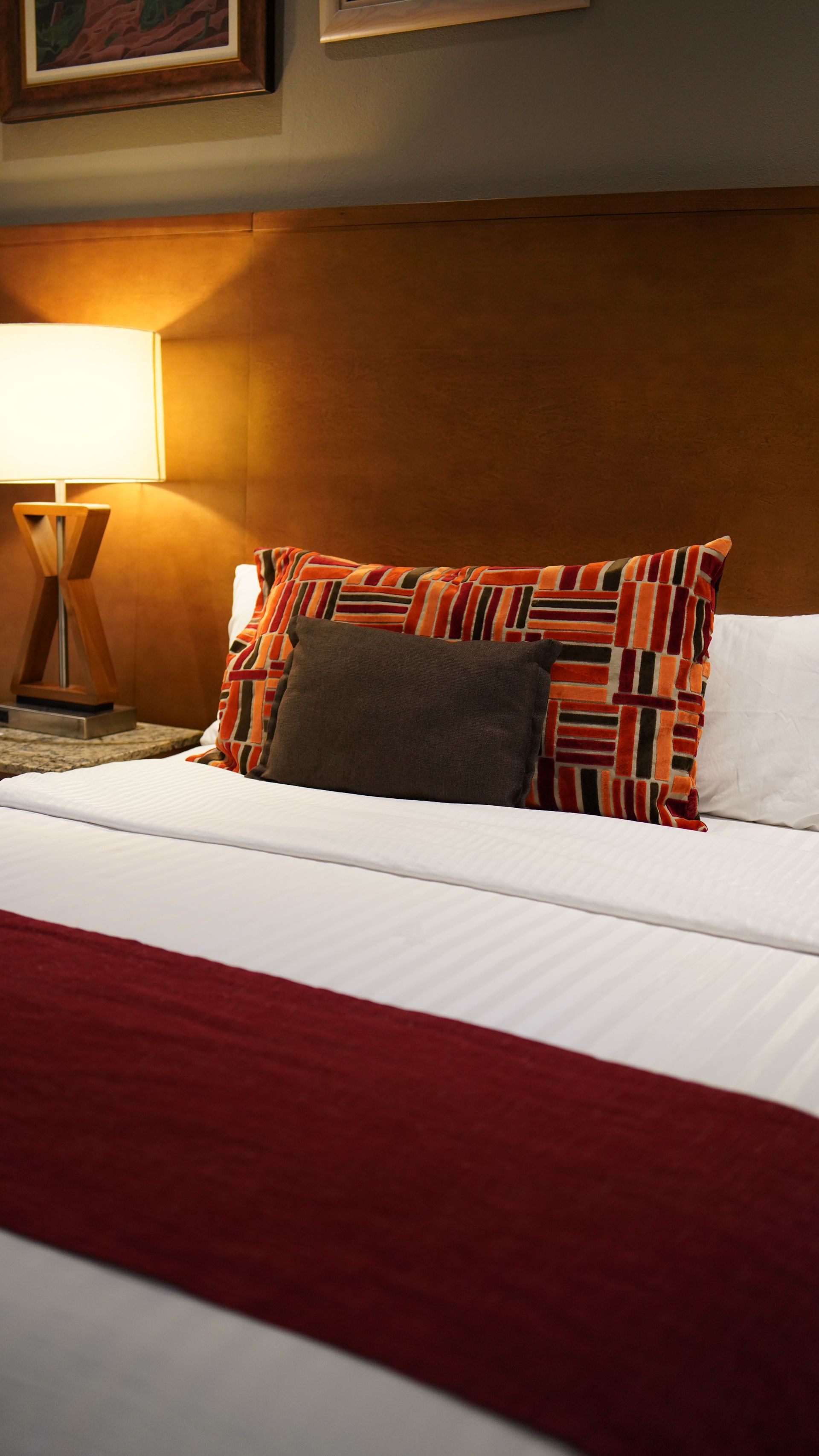 A hotel room with a bed and a lamp