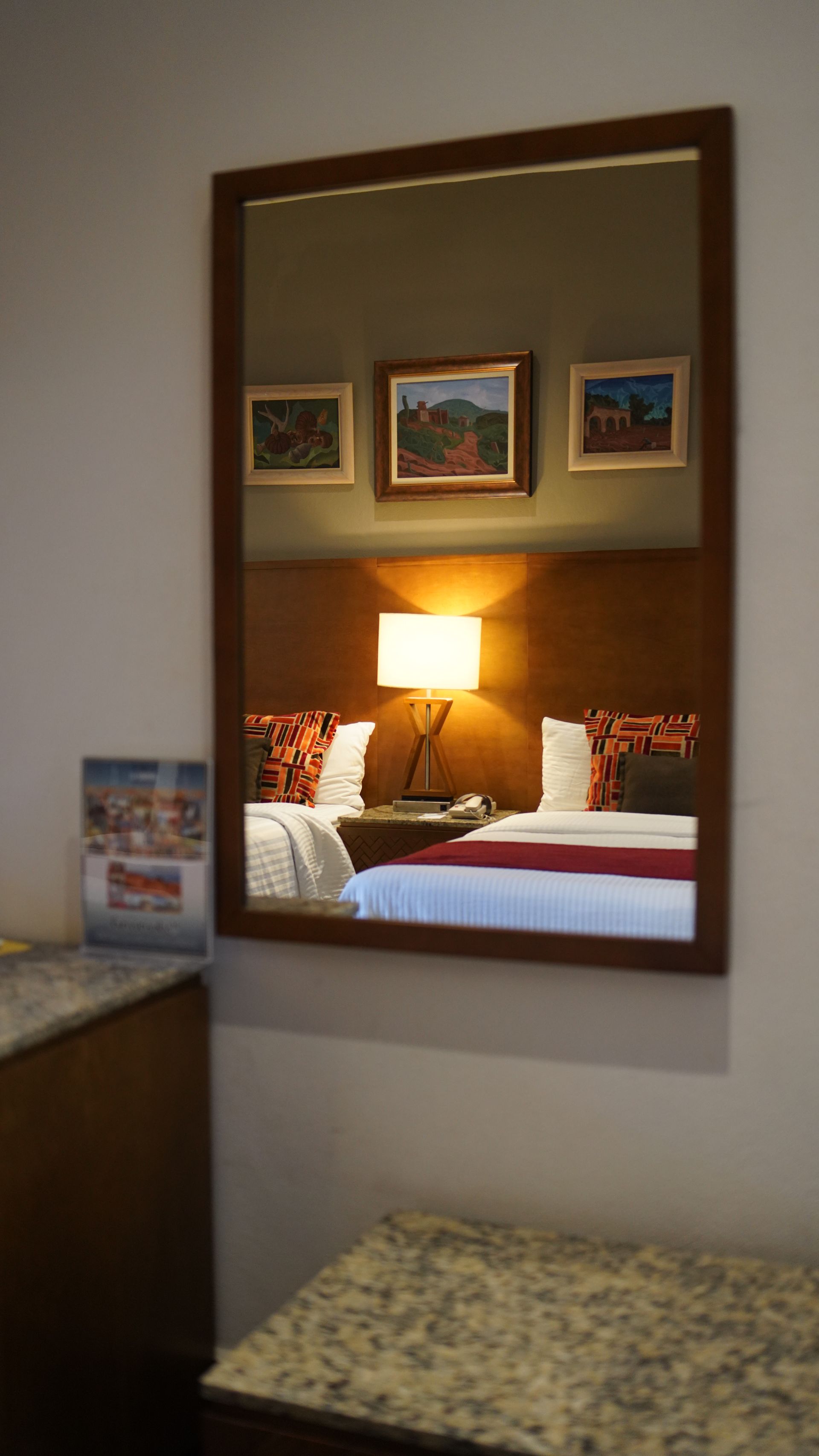 A hotel room with two beds and a large mirror