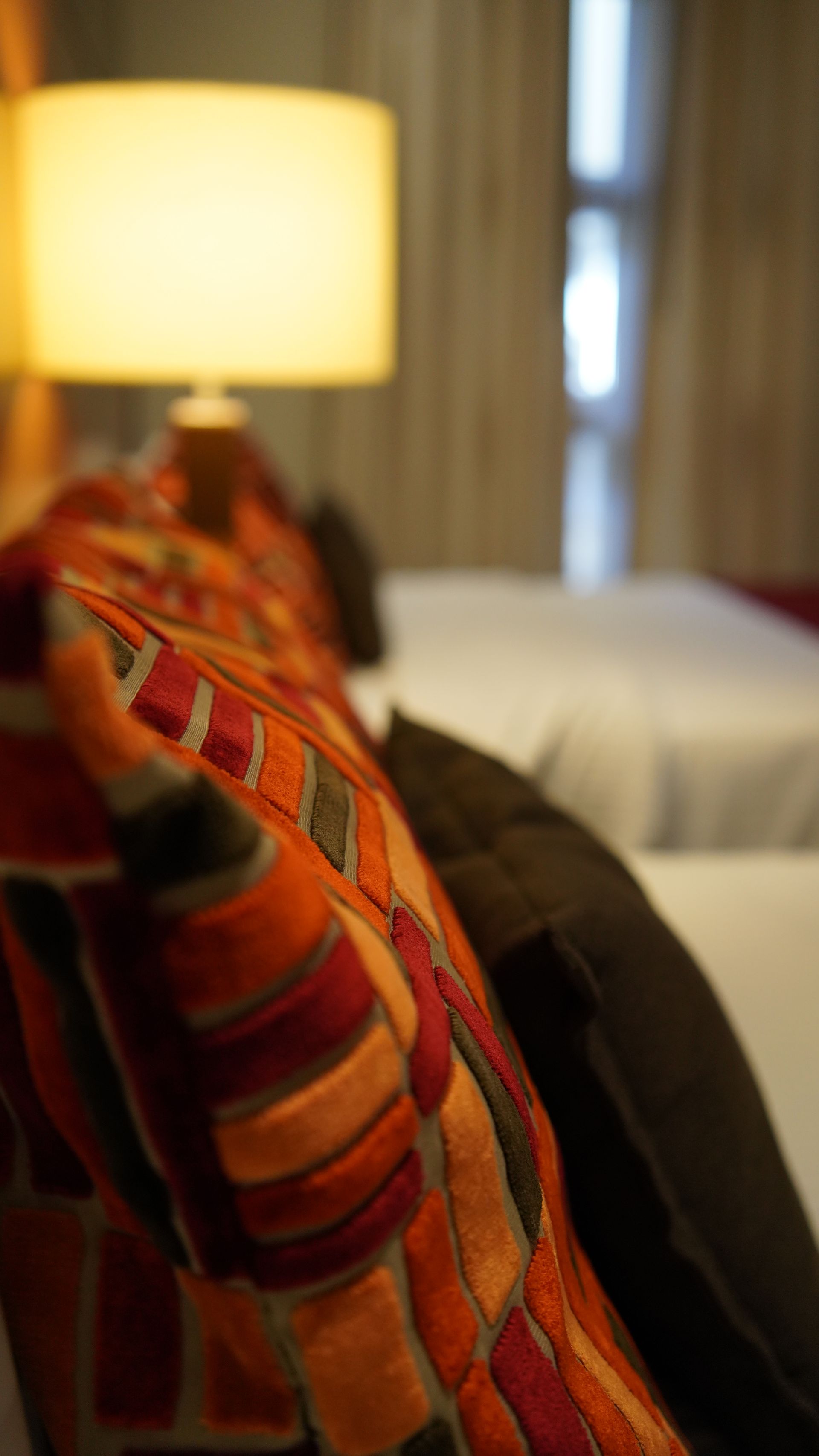 A close up of a pillow on a couch in a hotel room.