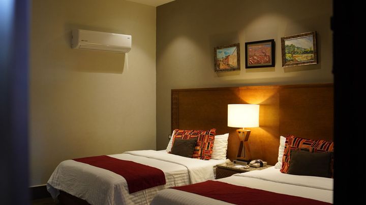 Una habitación de hotel con dos camas y una lámpara.