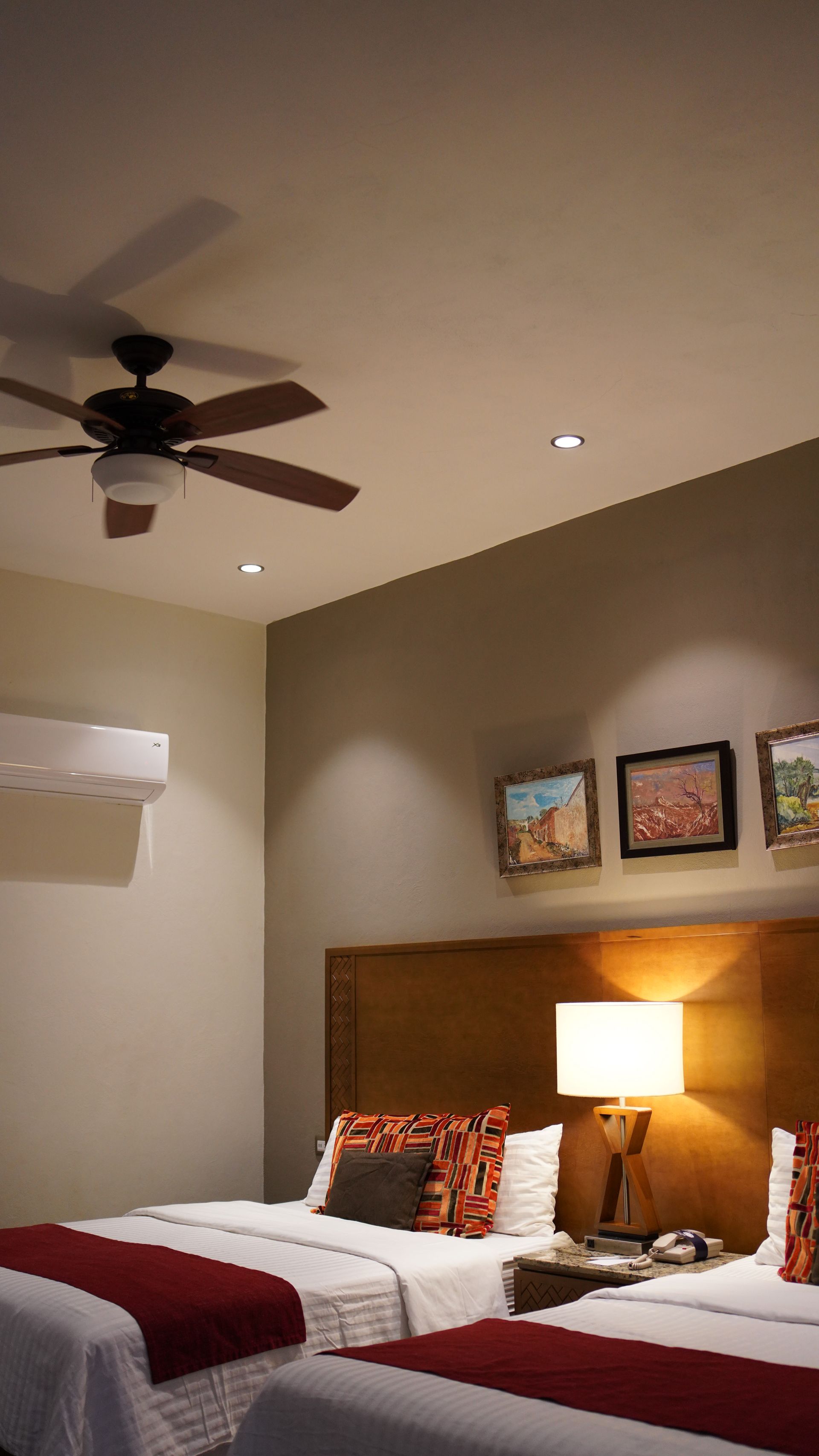 A hotel room with two beds and a ceiling fan.