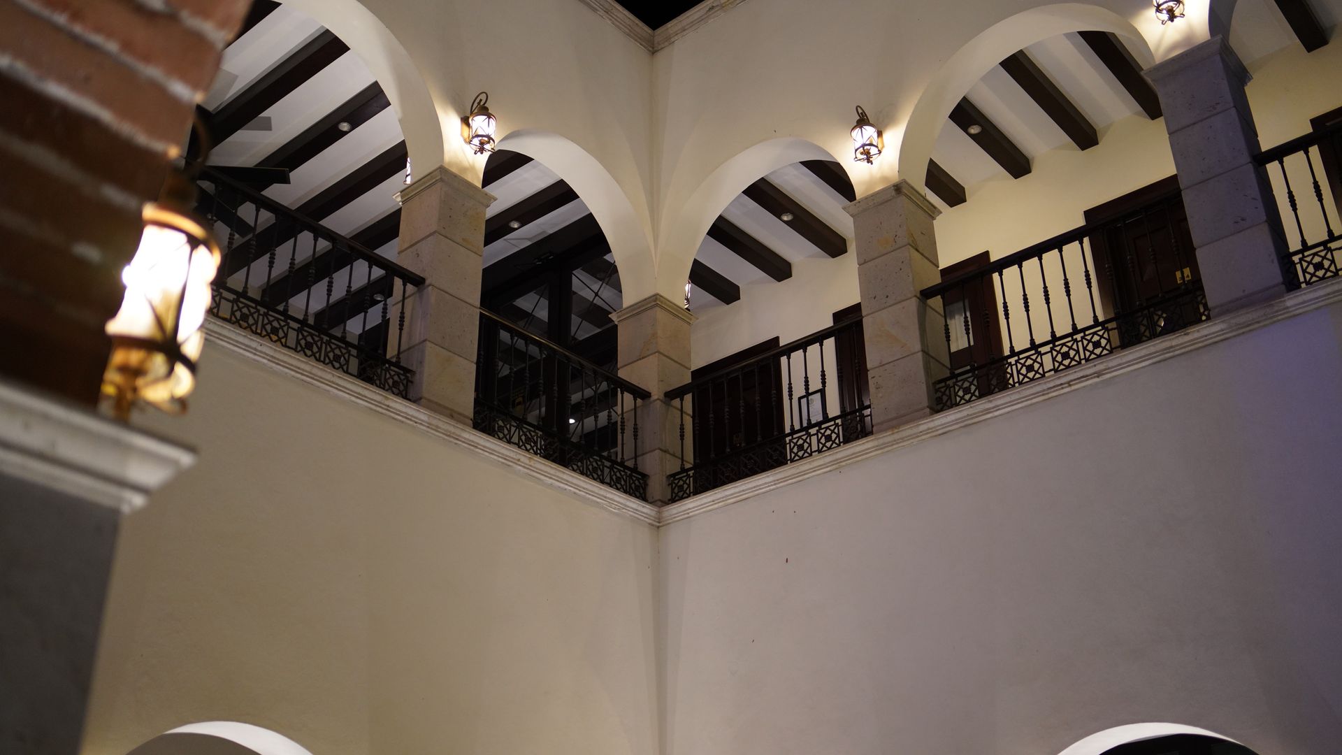 Looking up at the ceiling of a building with arches and balconies