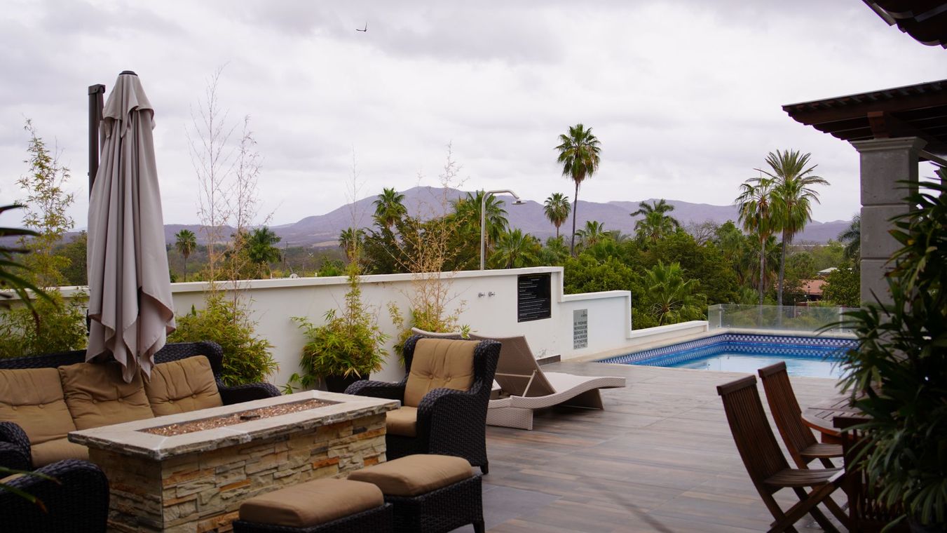 Un patio con fogata y piscina.