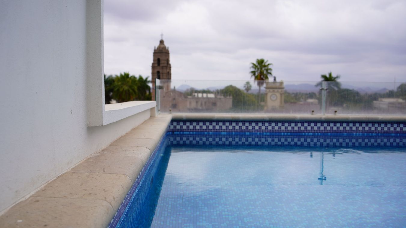 Una piscina con vistas a una ciudad en un día nublado.