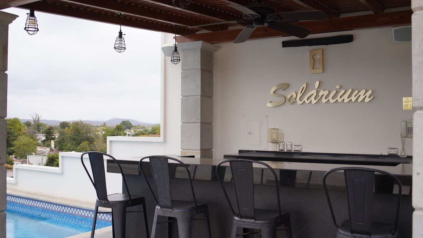 Un bar con una piscina al fondo y un cartel que dice solarium.