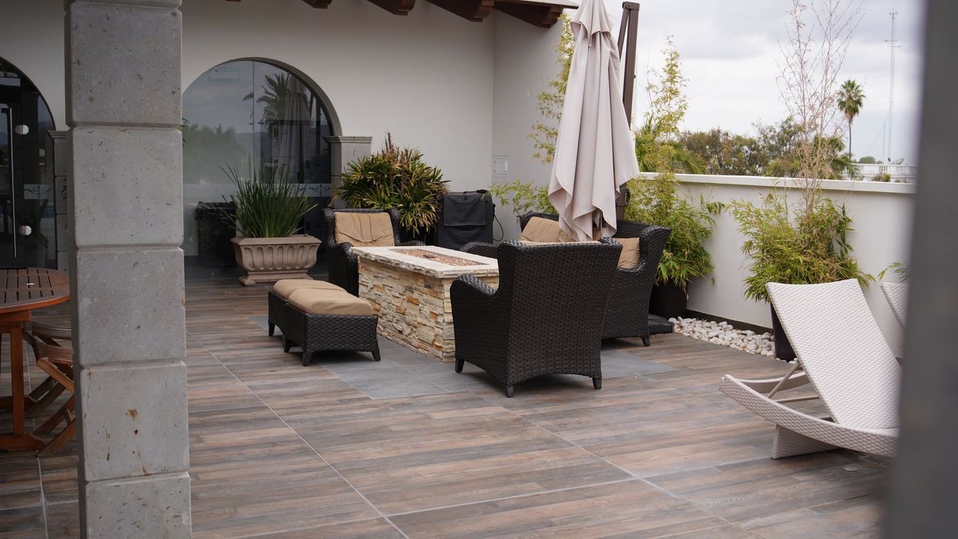 Un patio con muebles de mimbre y una fogata.