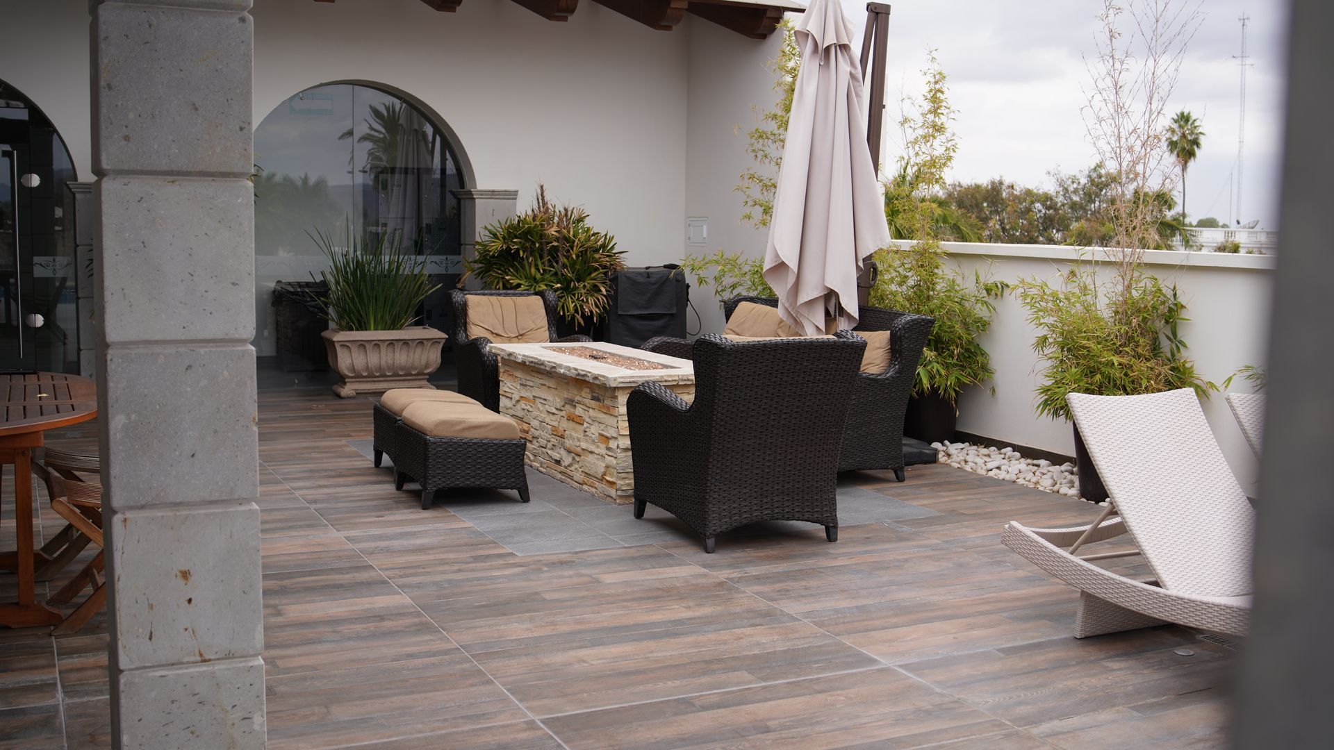 Un patio con muebles de mimbre y una fogata.