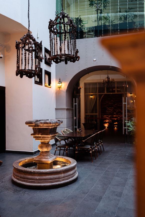 Una fuente en medio de un patio con una mesa y sillas.