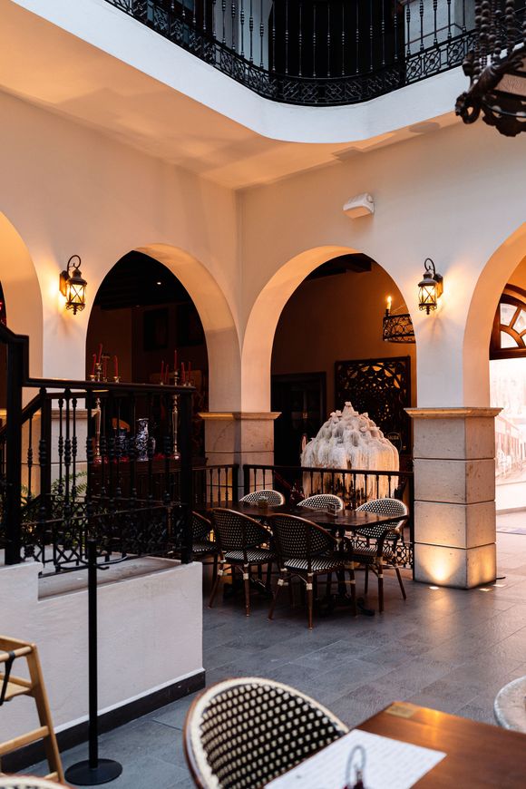 Un restaurante con arcos y mesas y sillas.
