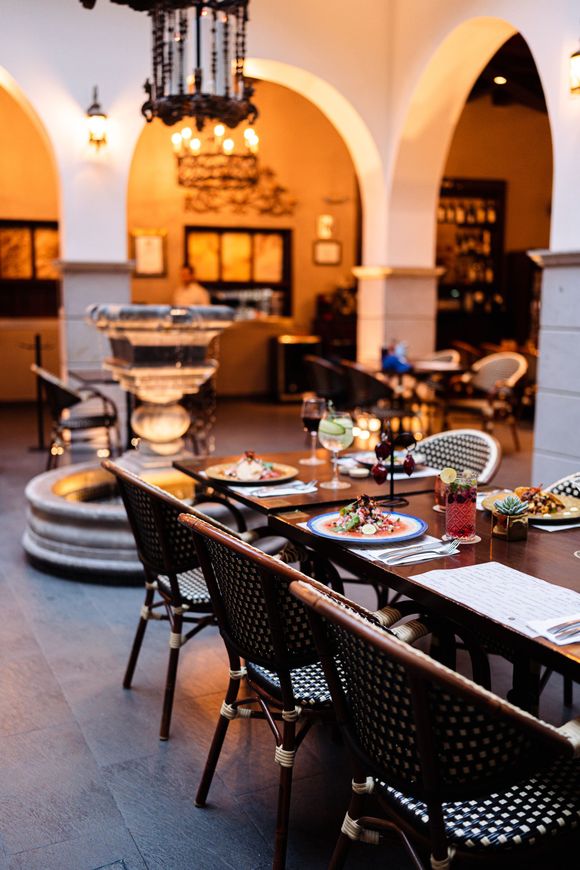 Un restaurante con mesas y sillas y una fuente en el medio.