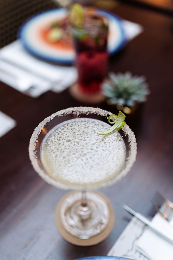 Un primer plano de una margarita en una copa de martini sobre una mesa.