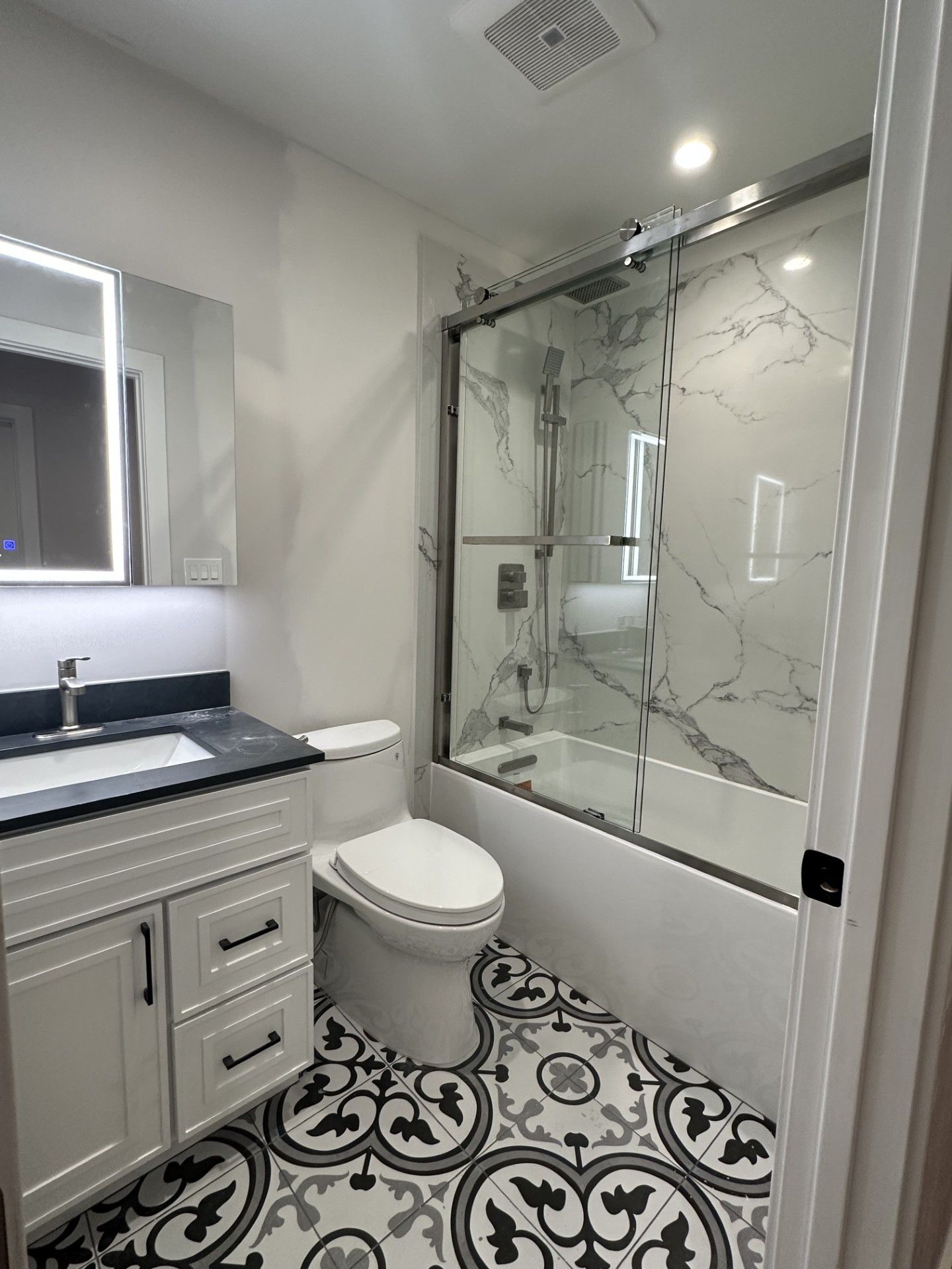 Bathroom remodel with glass shower and marble tile walls