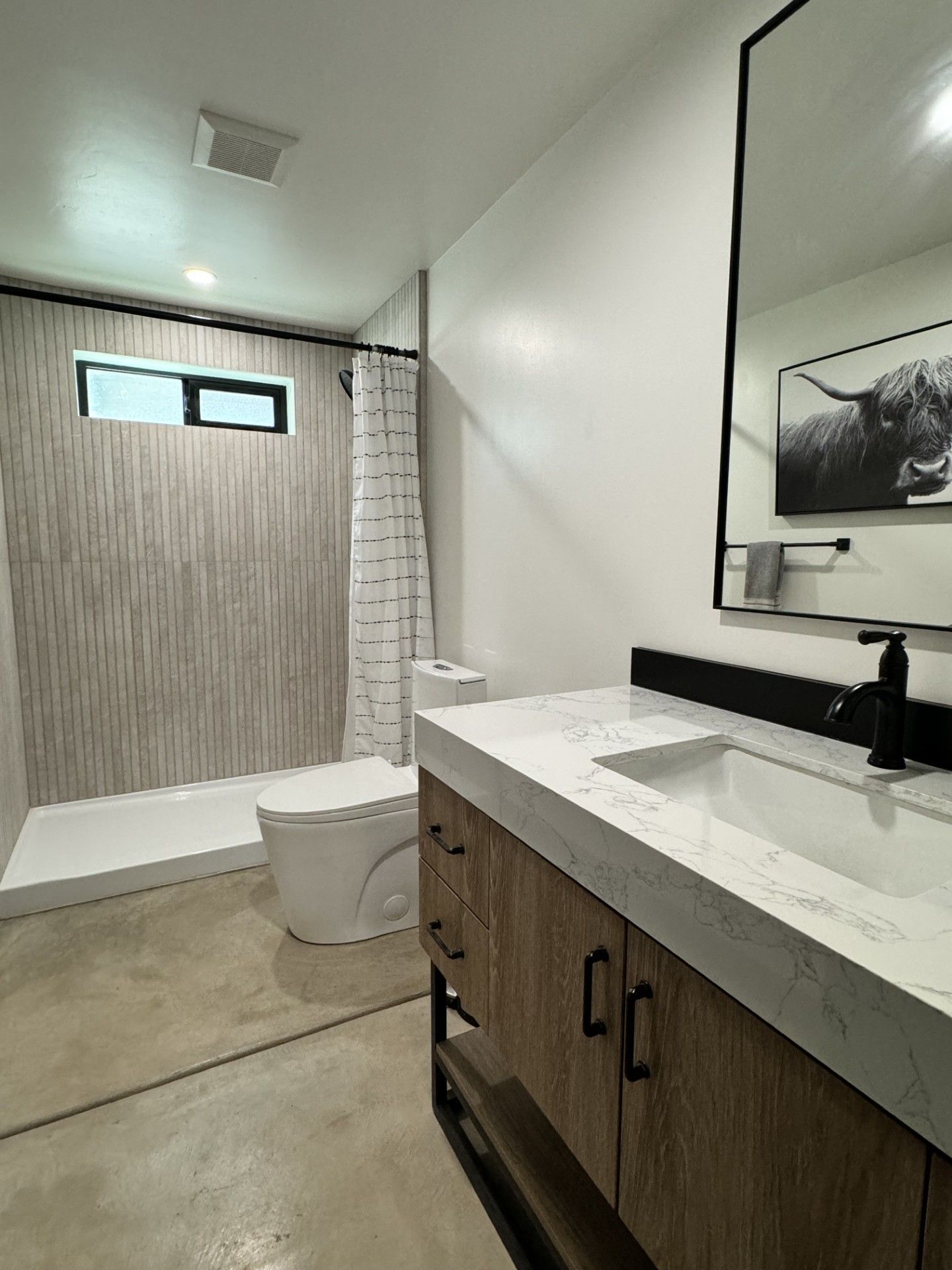 Bathroom renovation with tiled shower and wall mirror