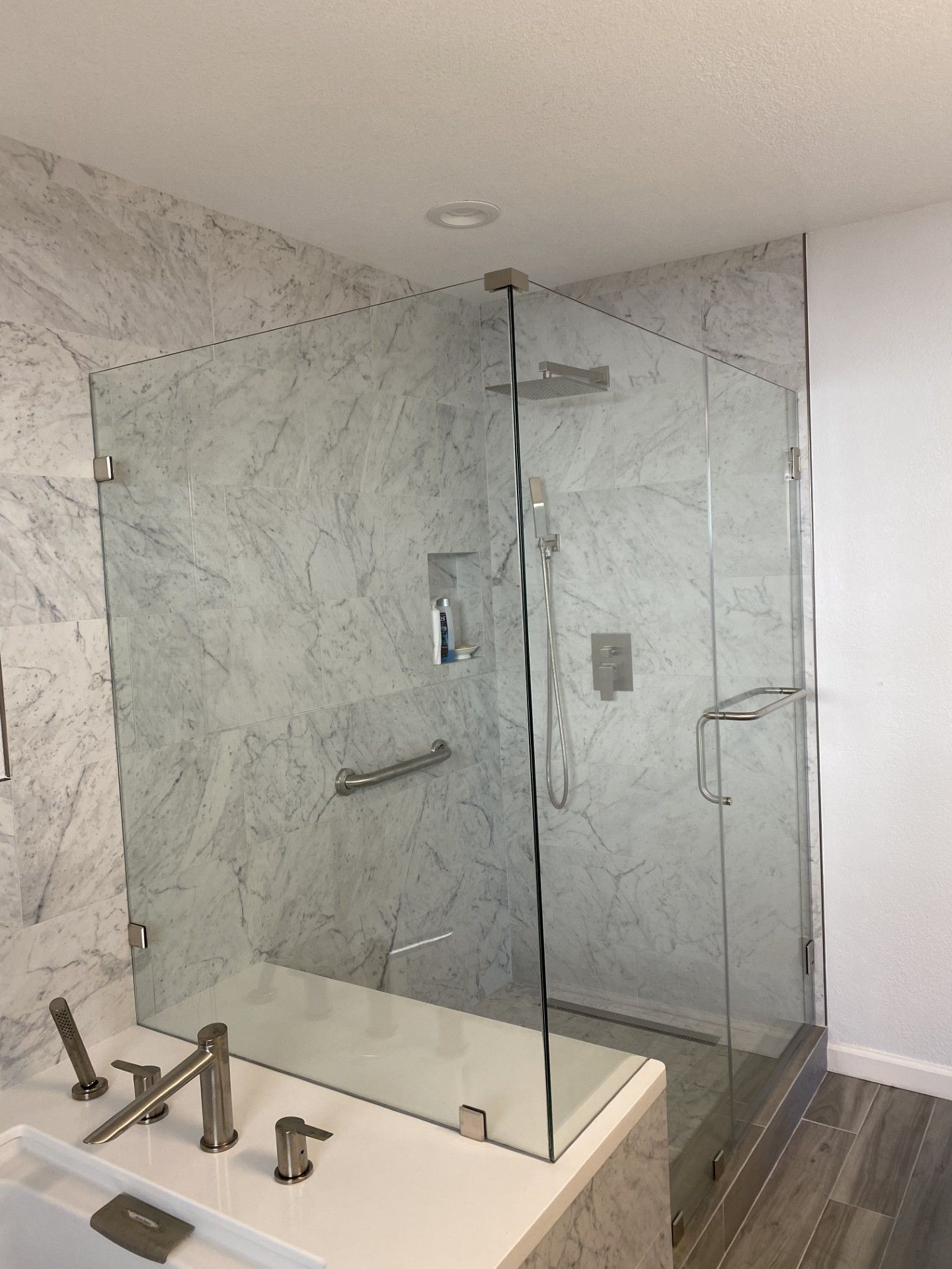 Marble shower with frameless glass enclosure